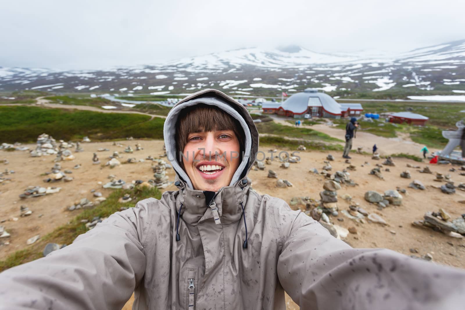 Tourist man making selfie Arctic circle center. Landmark on Lofoten islands. Norway.