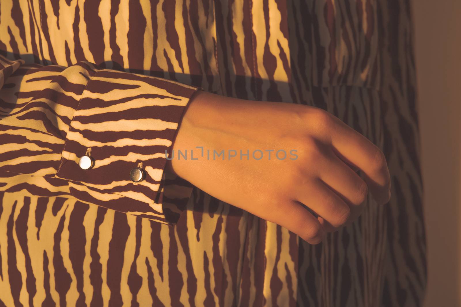 Human hand in evening sun, stylish shirt by photoboyko