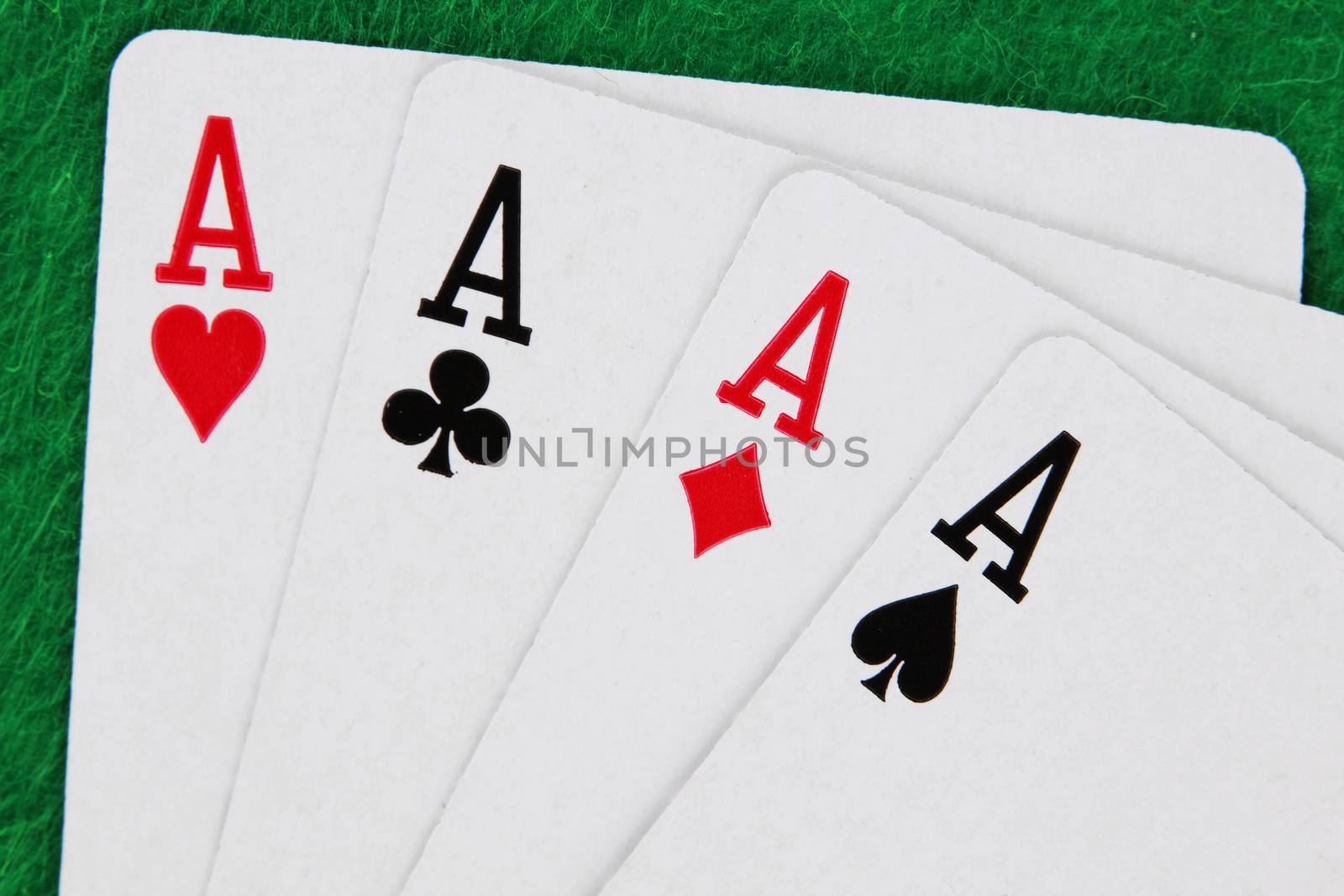 A run of Four aces with green casino table in background winning hand