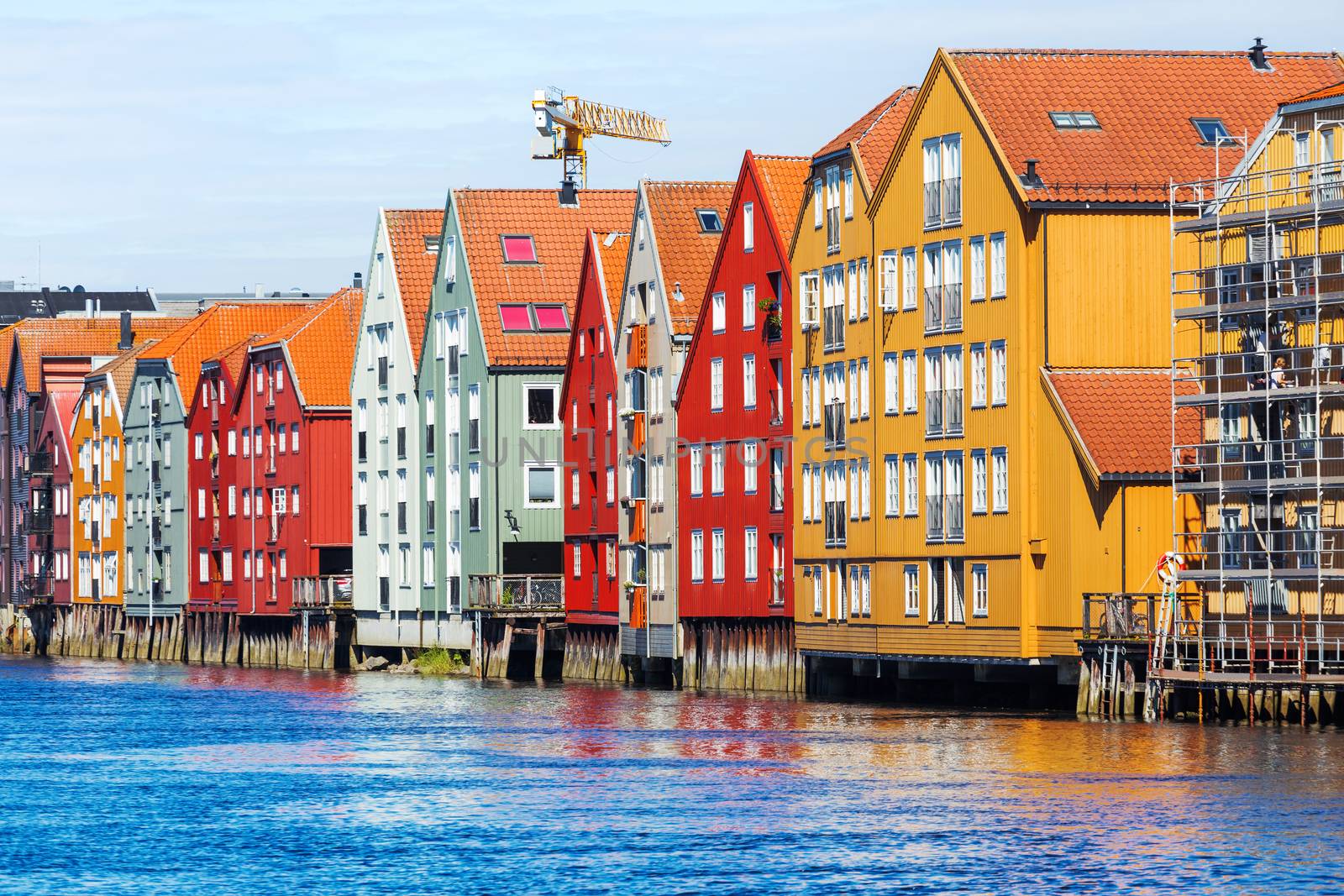 Famous wooden colored houses in Trondheim city, Norway. Colorful houses on stilts in sunny day.