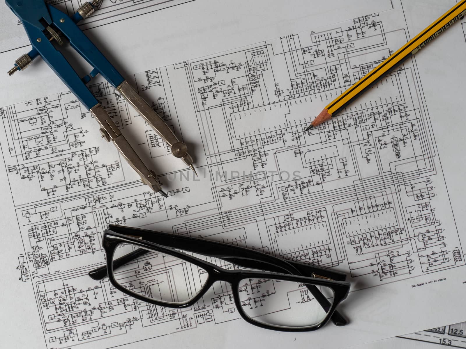 glasses, compasses, pencil and plans