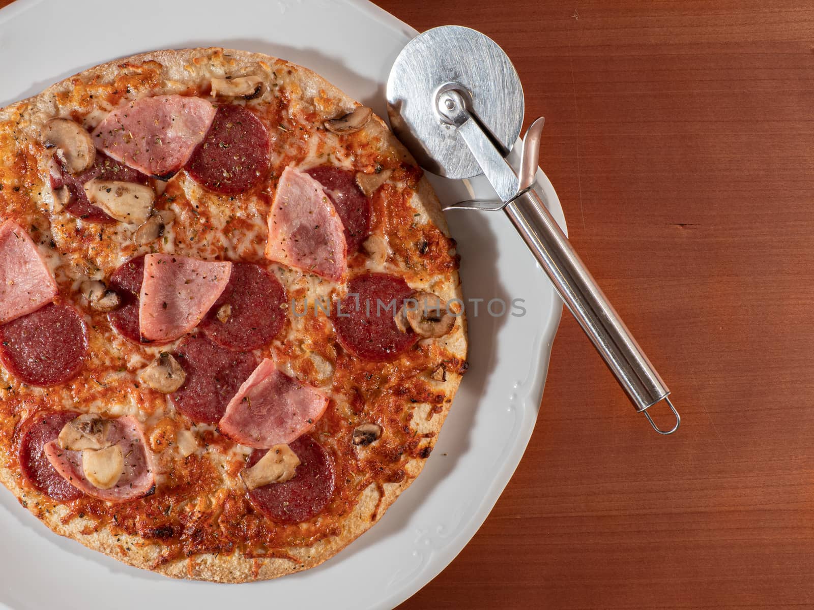homemade pizza on white plate and wooden background overhead view