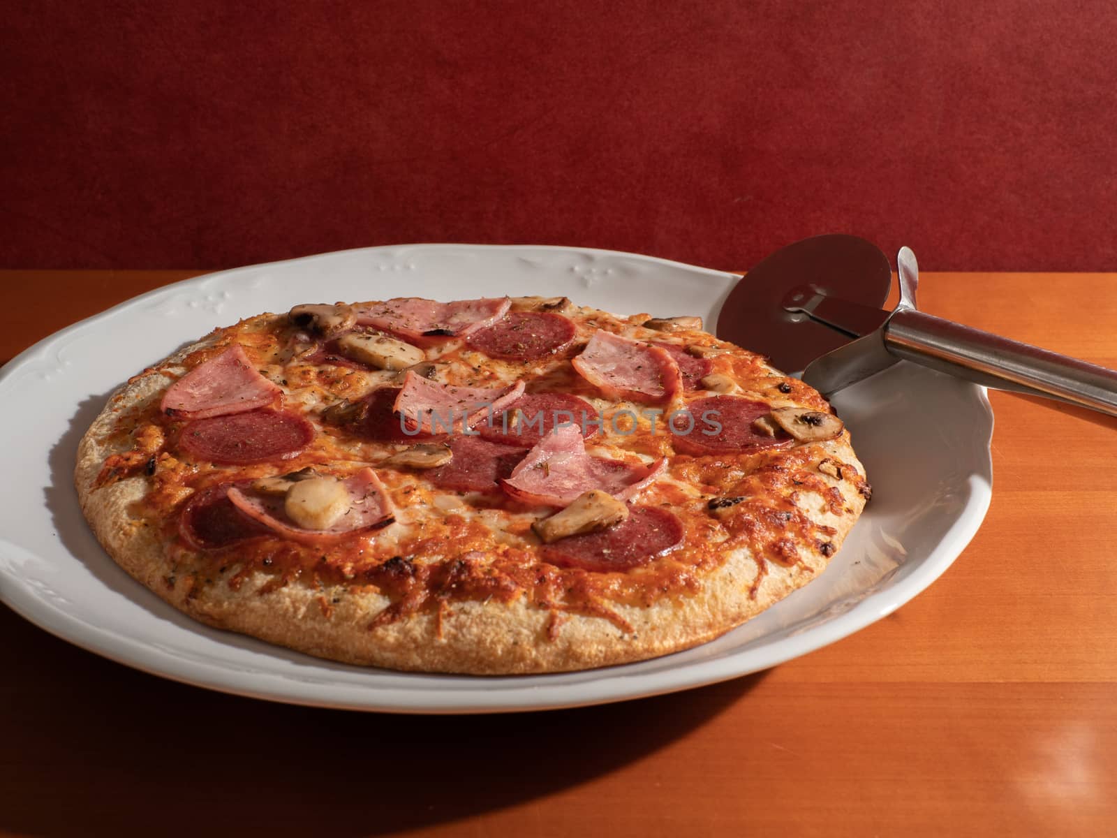 homemade pizza on white plate and wooden background overhead view