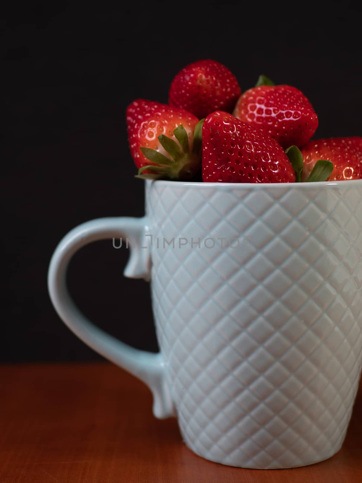 strawberries in a green ceramic cup