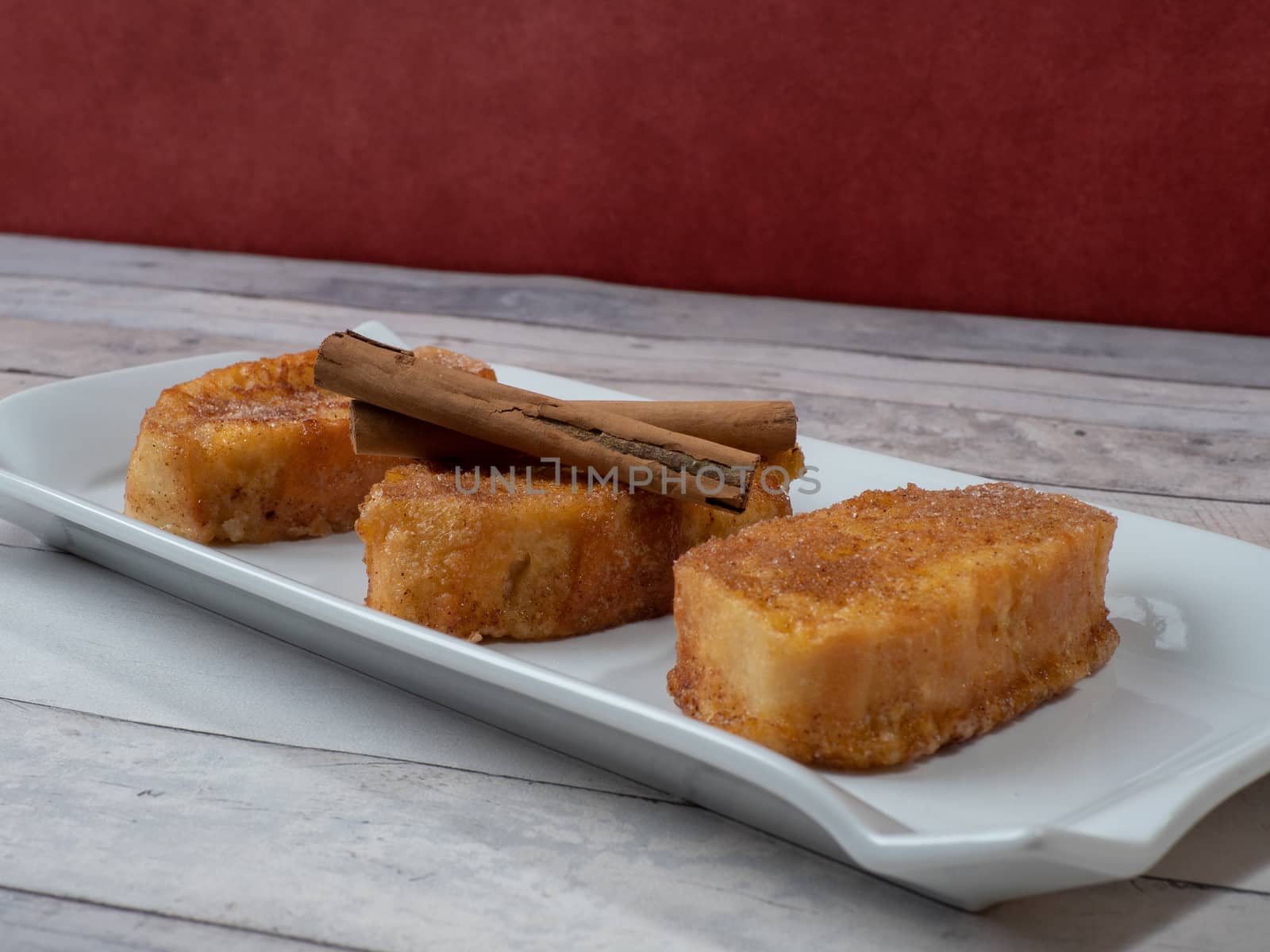 three french toast with cinnamon on white plate and light background