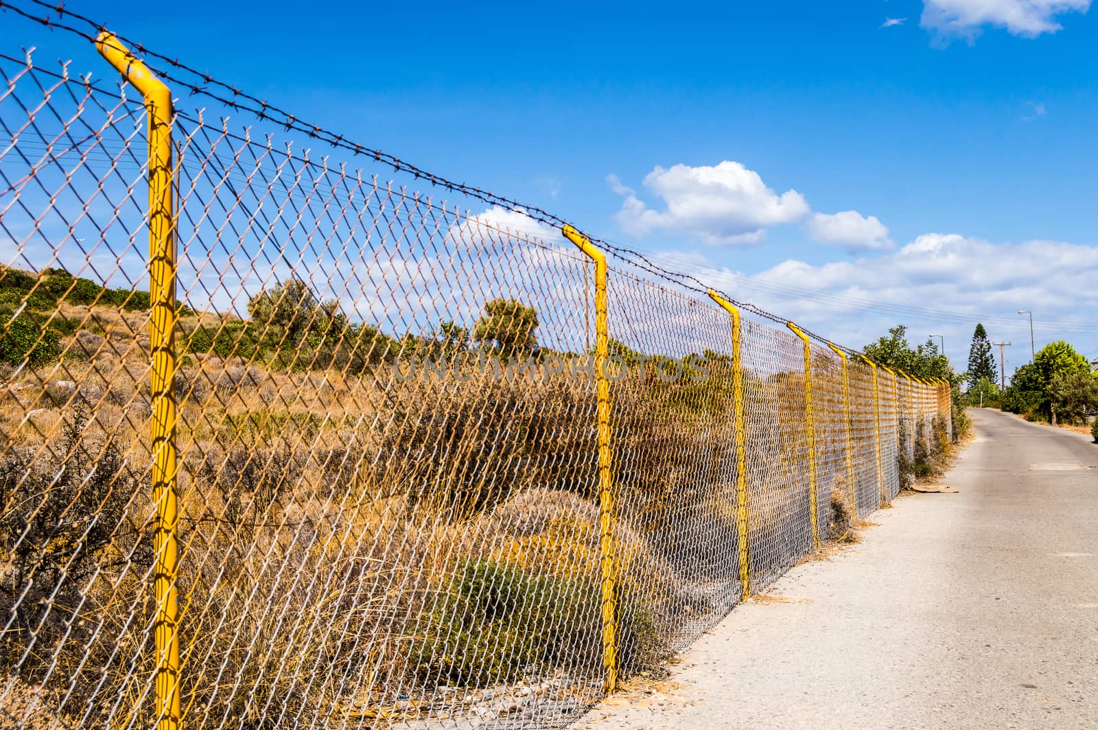 Industrial wire fence panels, metal fence panel and yellow stakes for a hill in Crete