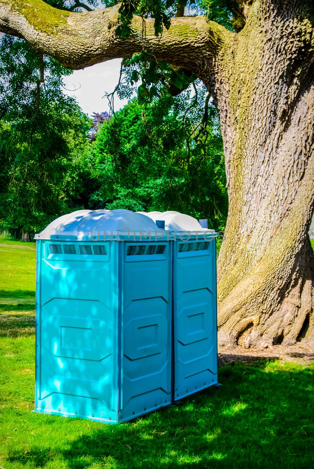 Two blue - white portable toilet cabins at outside event