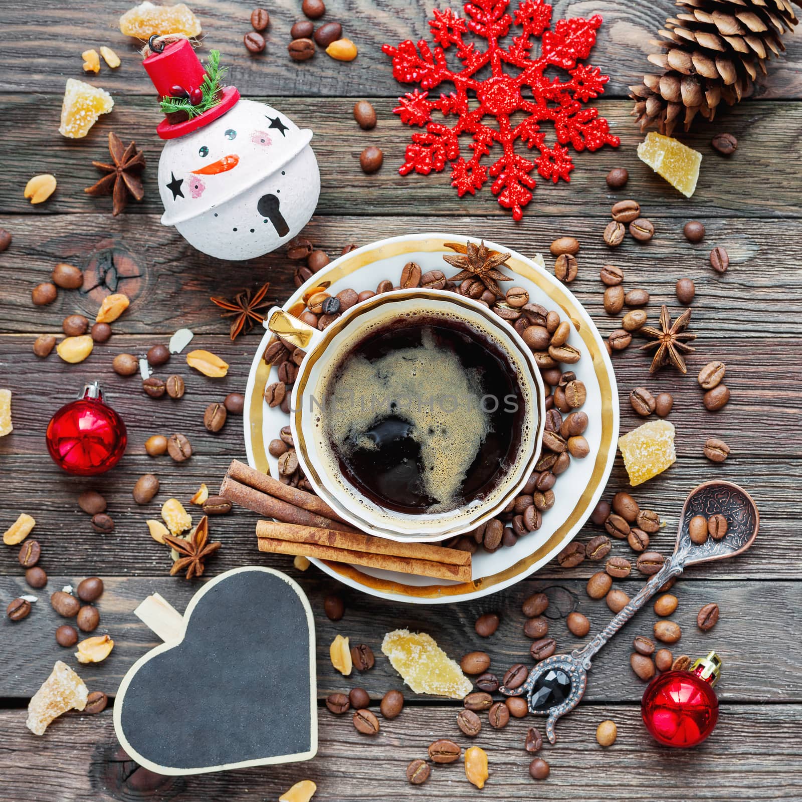 Rustic wooden background with cup of coffee and New Year decorations. Heart shaped chalkboard. Christmas beverage with ginger and anise. Top view, place for text. by aksenovko