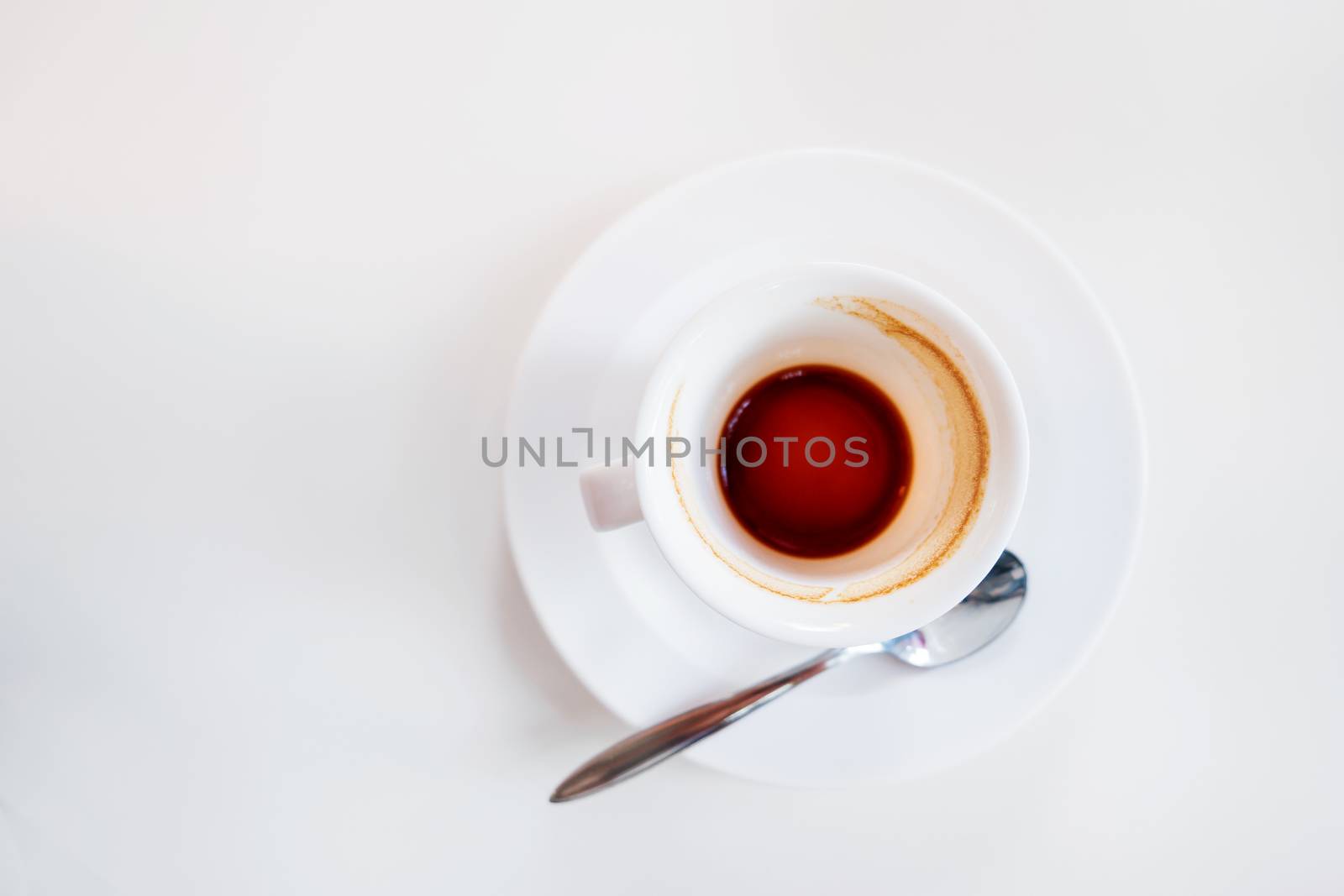 Empty coffee cup on white background. End of coffee break. Coffee grinds in white mug.