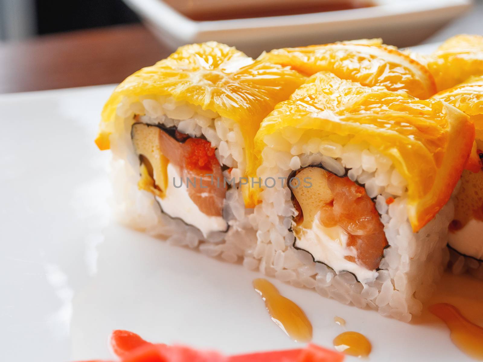 Rolls with rice, seaweed nori, salmon, cream cheese, chicken egg, caviar masago, orange. Marinated ginger and wasabi sauce. Asian cuisine, traditional dish - sushi.