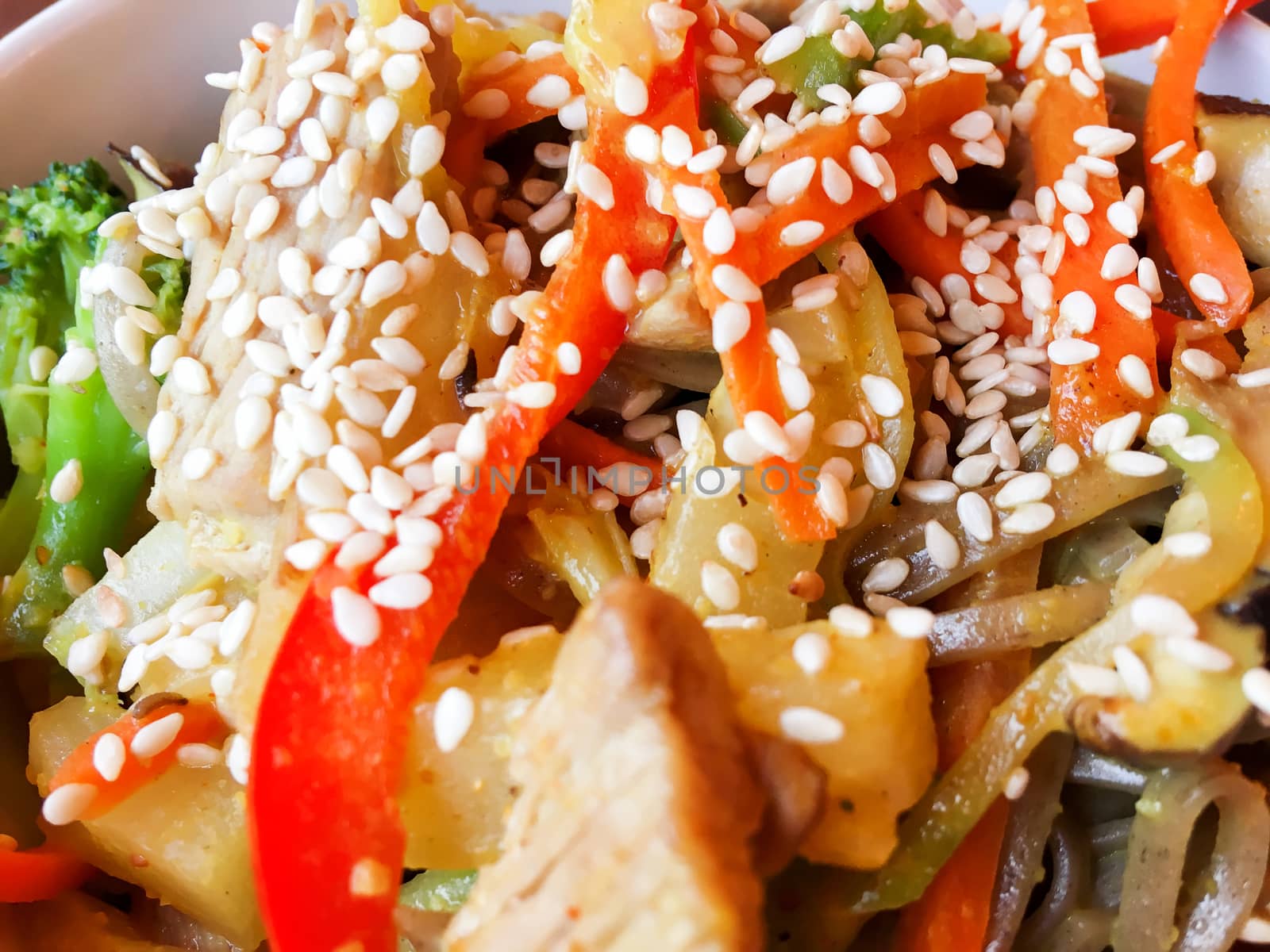 Asian cuisine - noodle in sauce with stir fried vegetables and chicken meat in white bowl. Close up.