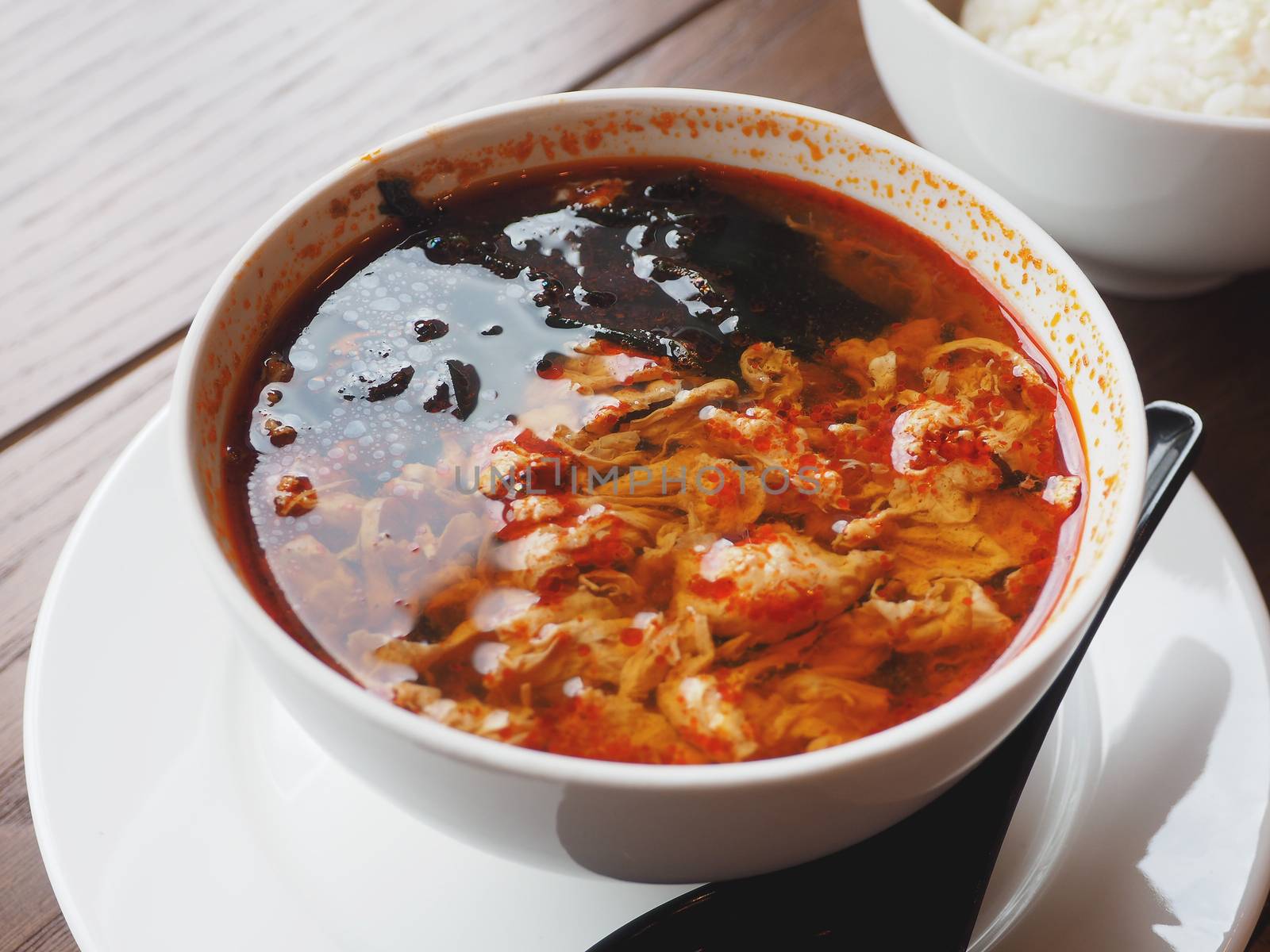 Asian cuisine - Kimchi soup in white bowl with rice. Close up photo.