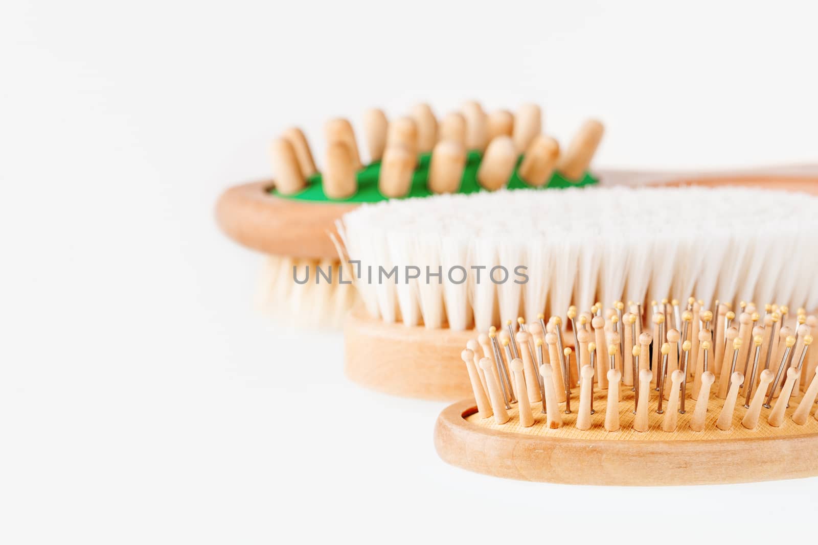 Three combs on white background. Different types of massage and hair brushes.
