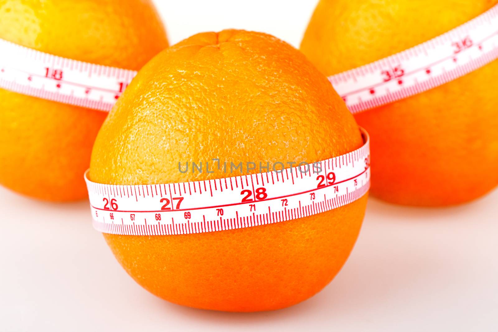 Three oranges with tailor's ruler. Orange diet. Fruit healhy vitamin diet helps to lose weight.