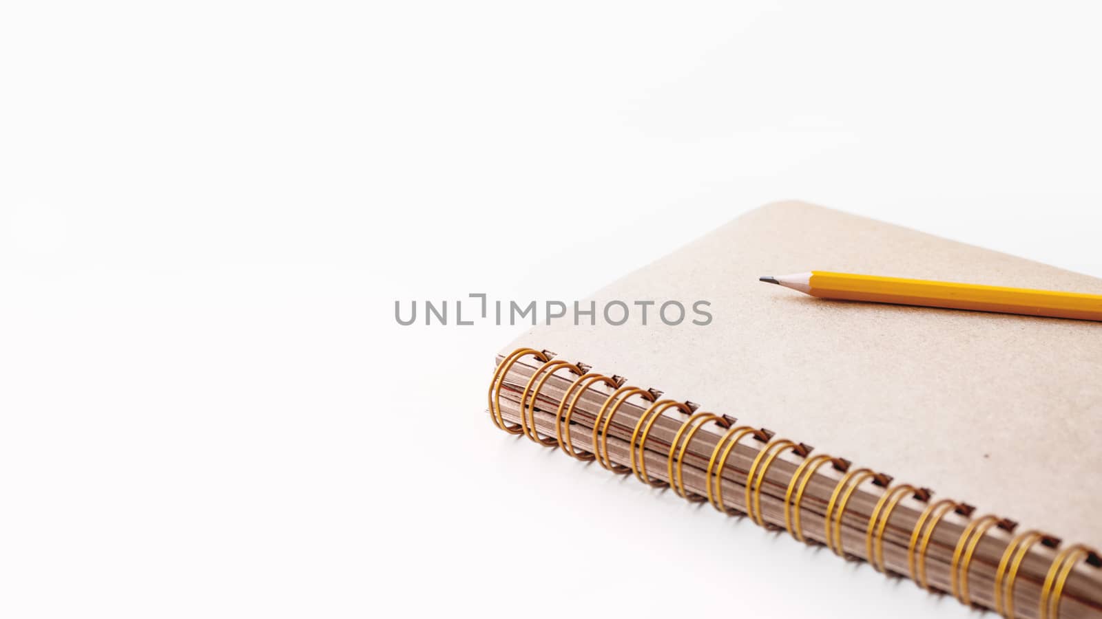 Notepad with craft paper pages and orange pencil. Banner with copy space.