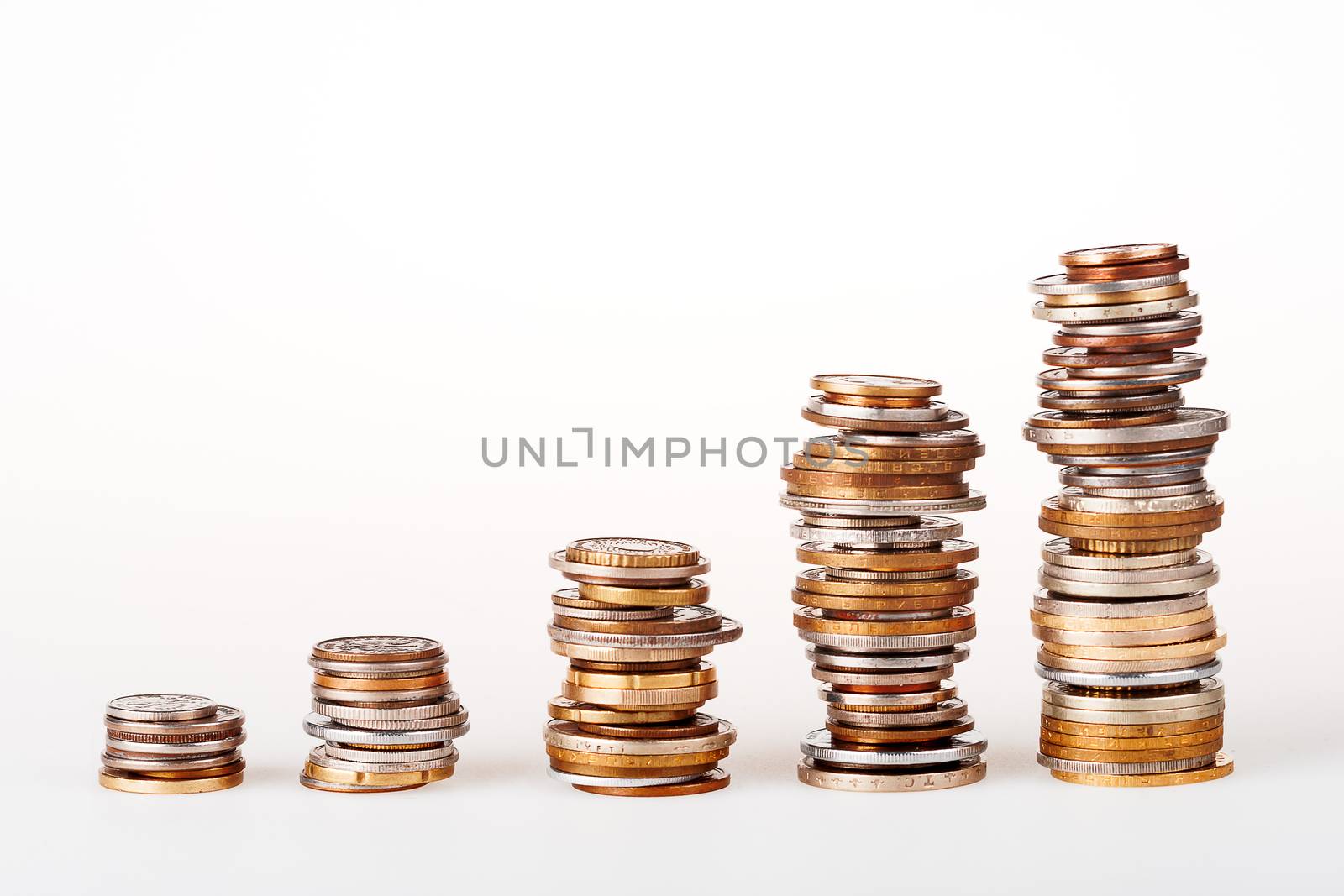 Set of five column of different coins staying in a row on white background. May be used as symbol of increase in wealth or money diagram.