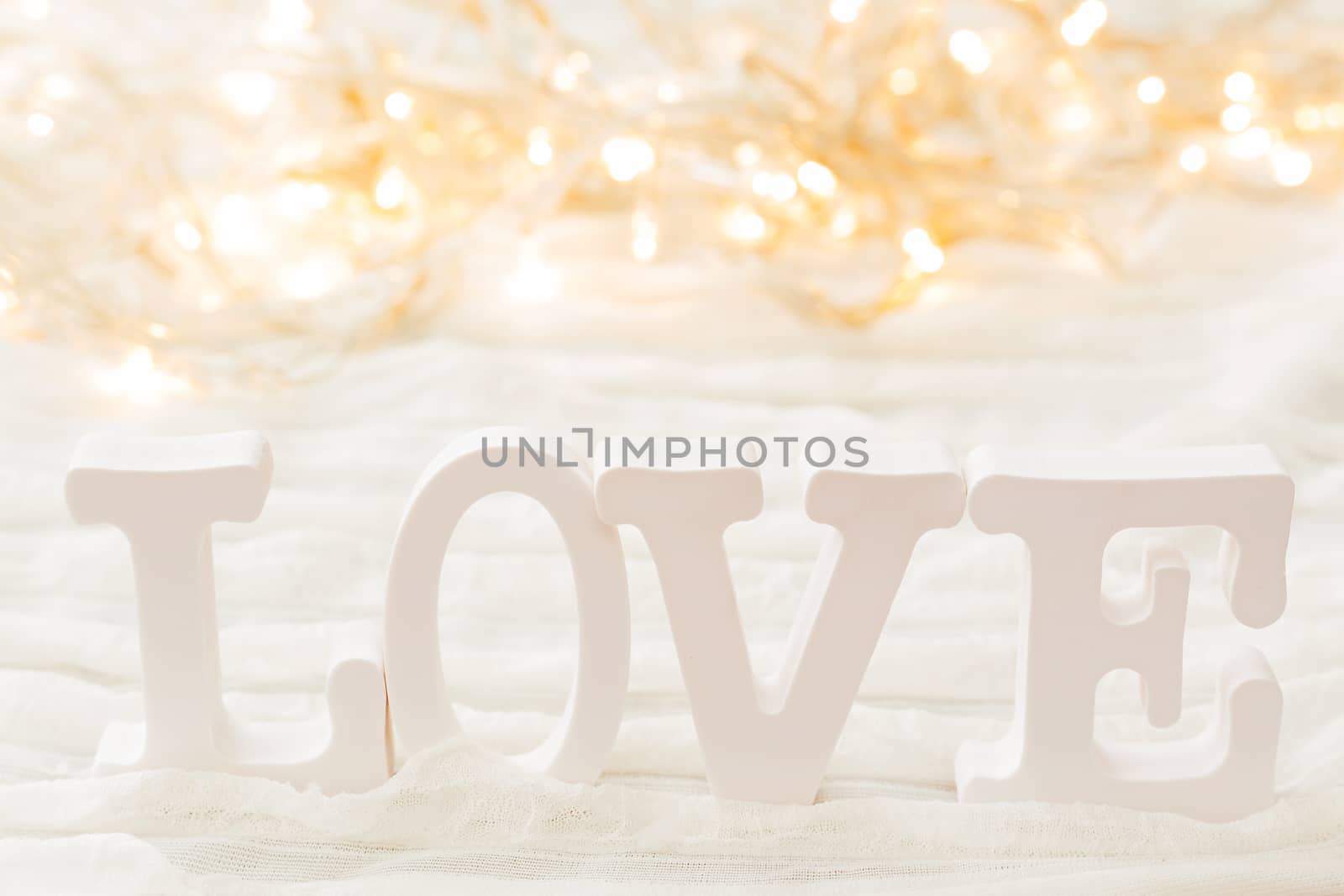 Word LOVE on white background with light bulbs. Can be used as Valentine's Day card.