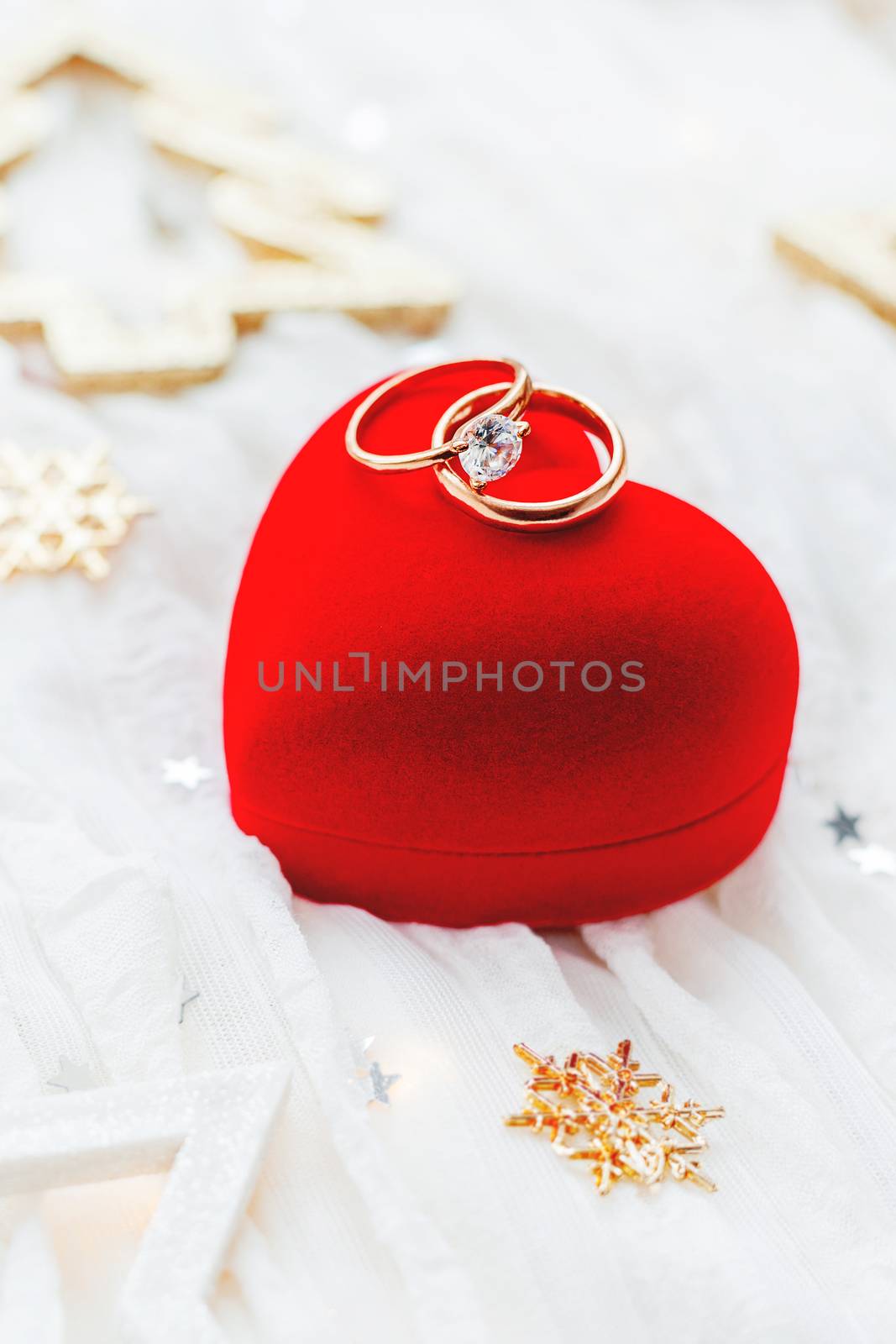 Christmas and New Year holiday background with decorations and wedding rings on gift heart box.