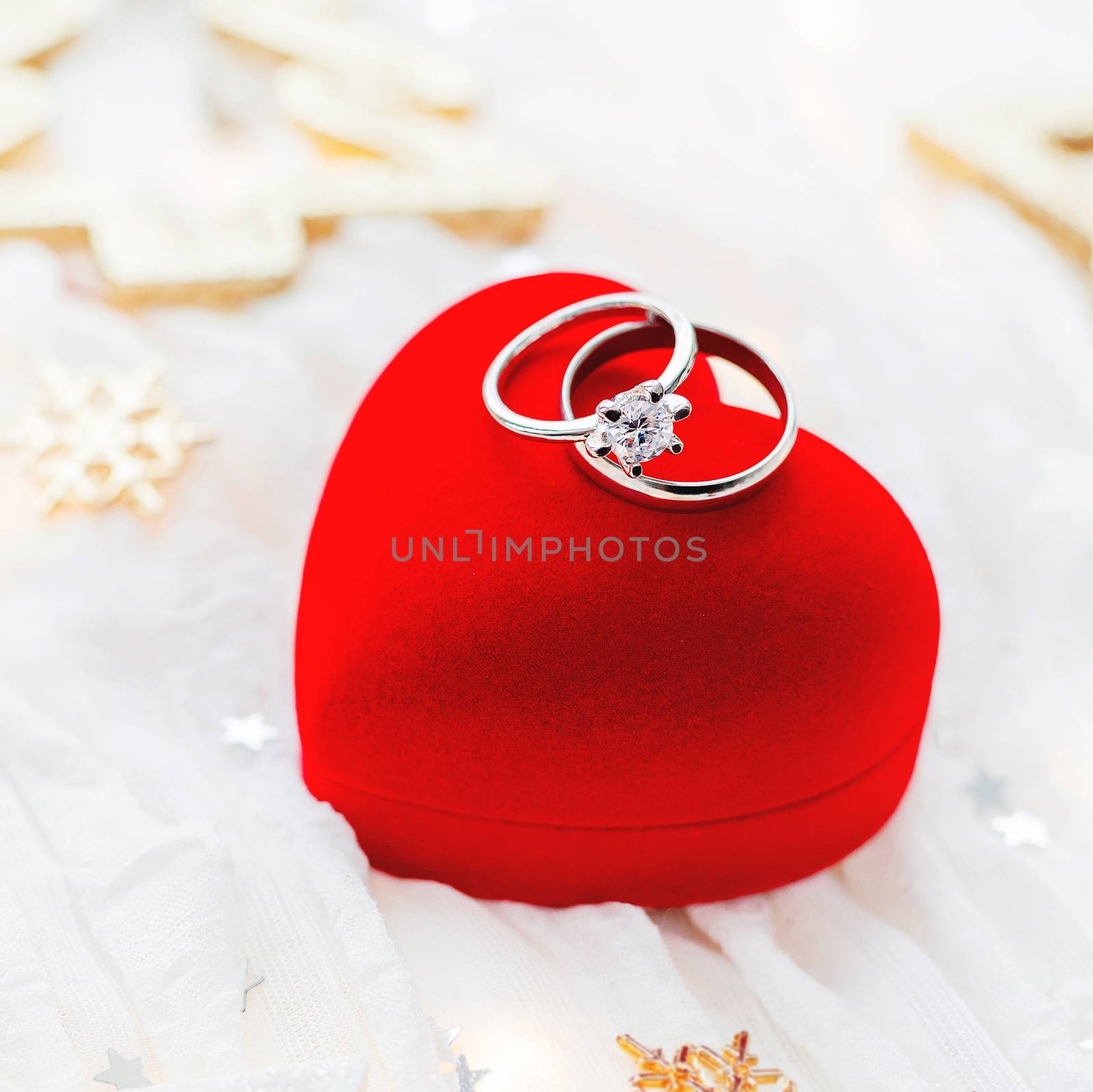 Christmas and New Year holiday background with decorations and wedding rings on gift heart box.