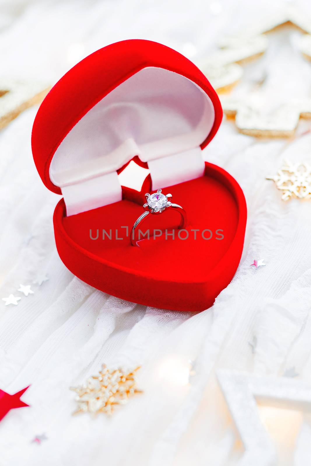 Christmas and New Year holiday background with decorations and engagement golden ring with diamond in gift heart box. Valentine's Day card.