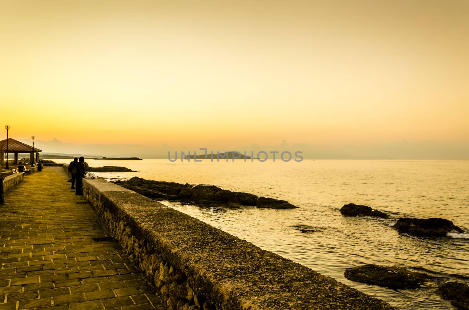 The afternoon falls and people watch the horizon.