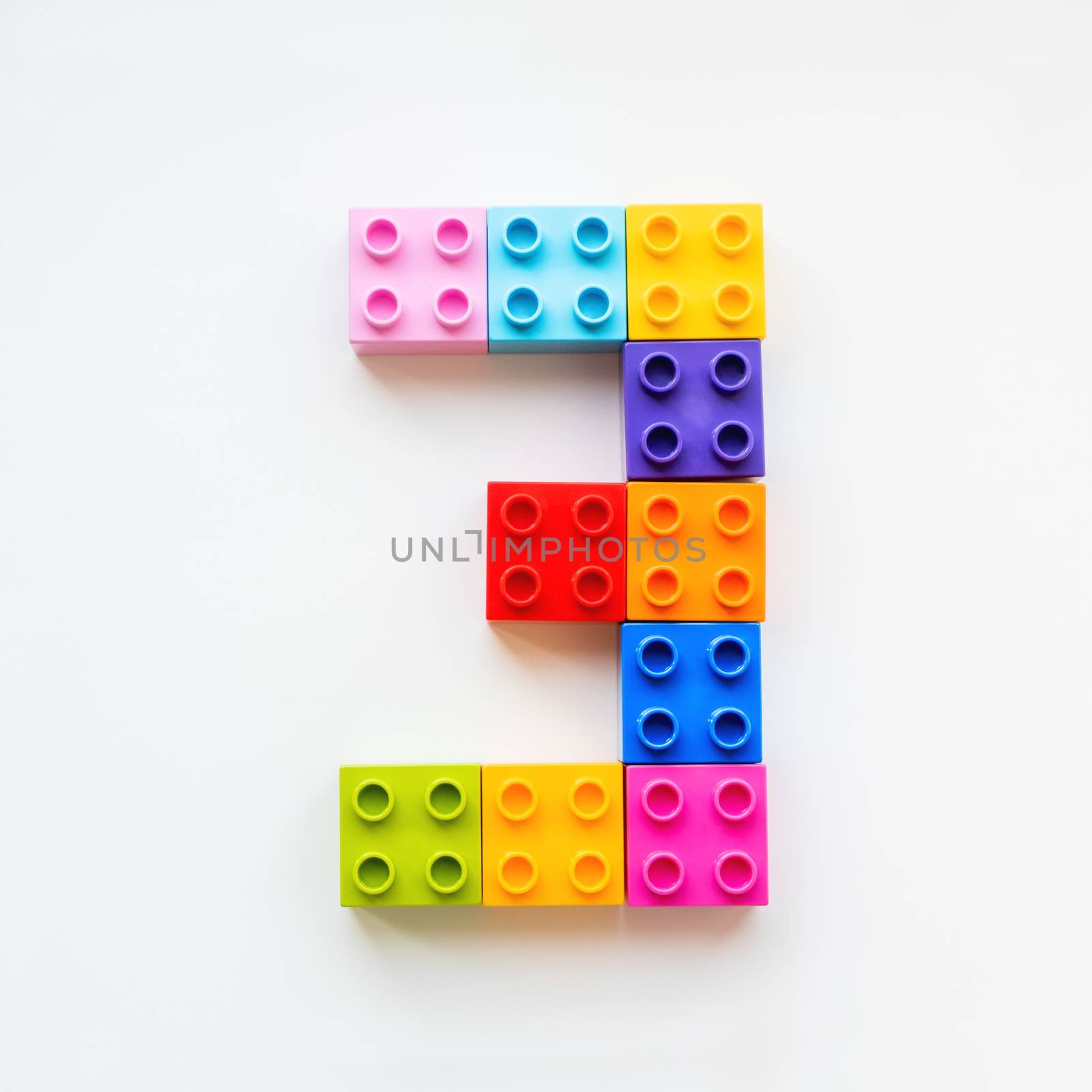 Number Three made of colorful constructor blocks. Toy bricks lying in order, making number 3. Education process - learning numbers with child using multicolored toy details.