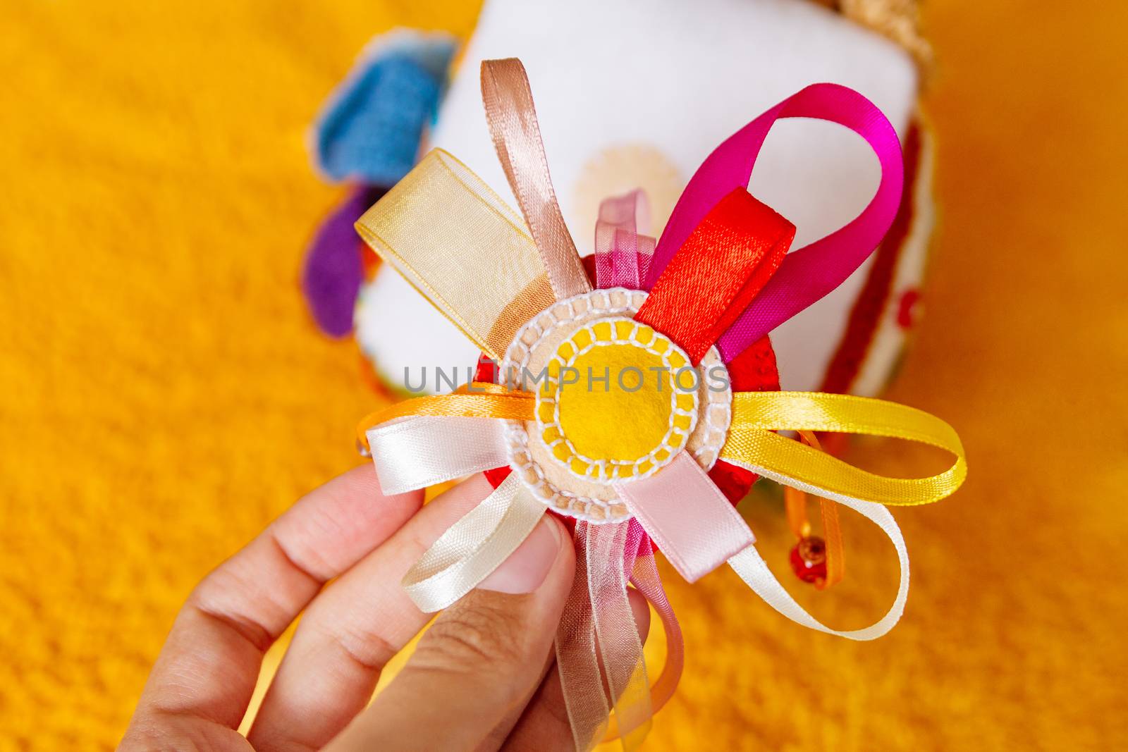 Colorful hand made toy for toddlers and babies. Busy cube. Soft baby block made of fabric to develop skills and fine motor skills. Taggie Cube. Montessori busy toy.
