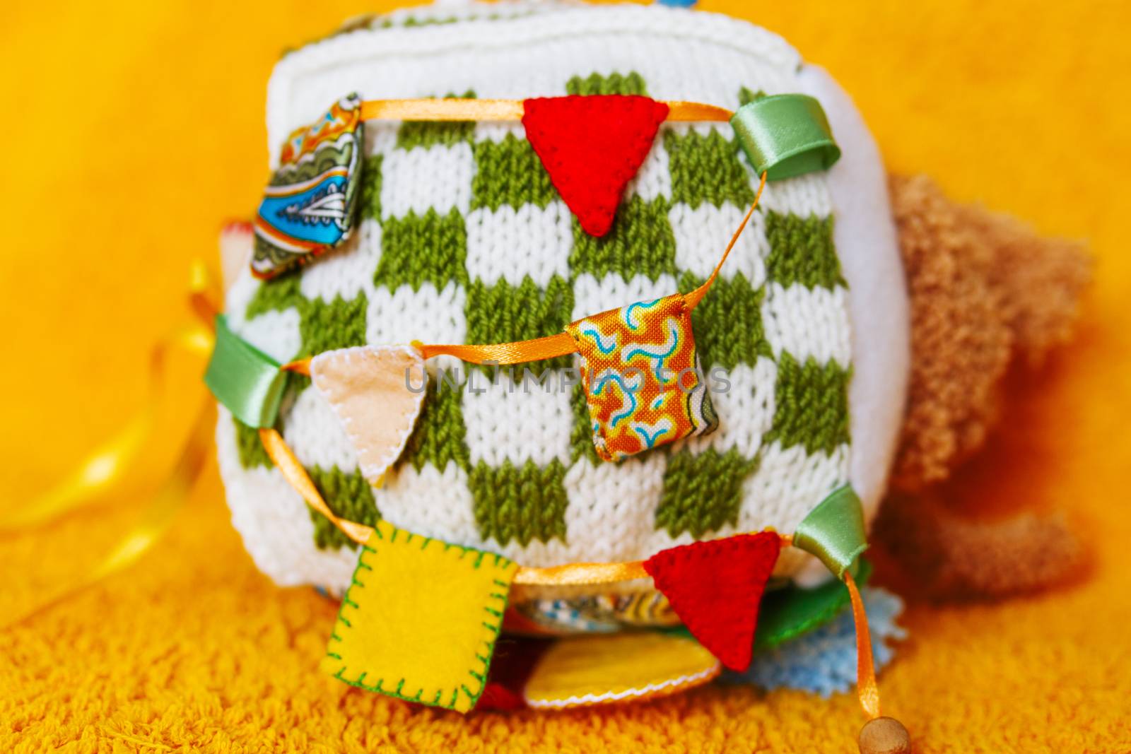 Colorful hand made toy for toddlers and babies. Busy cube. Soft baby block made of fabric to develop skills and fine motor skills. Taggie Cube. Montessori busy toy.