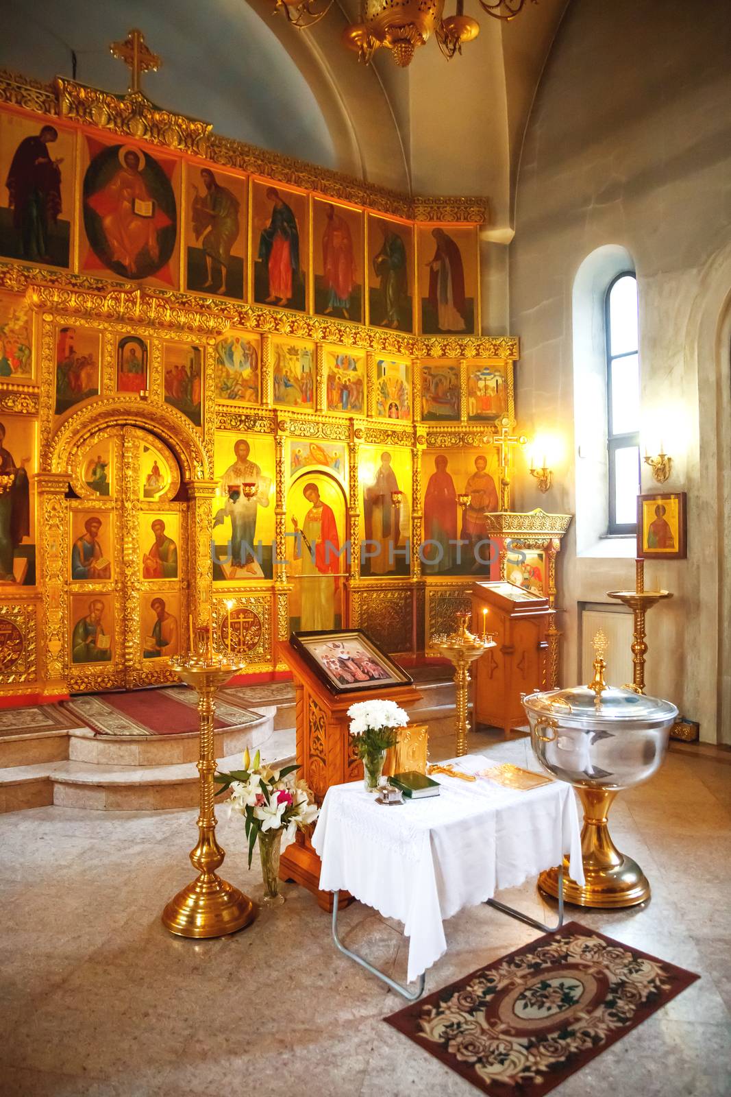 Golden religious utensils - Bible, cross, prayer book, missal, baptismal font. Interior of Orthodox Christian Church. Russia.