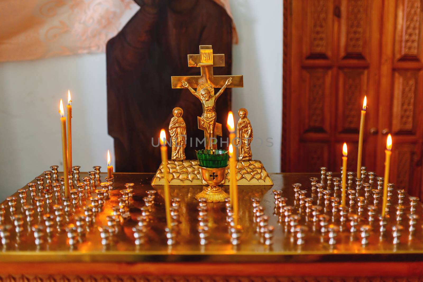 Golden candleholder in Orthodox church. Symbolic Orthodox gold cross with the crucifixion of Jesus.