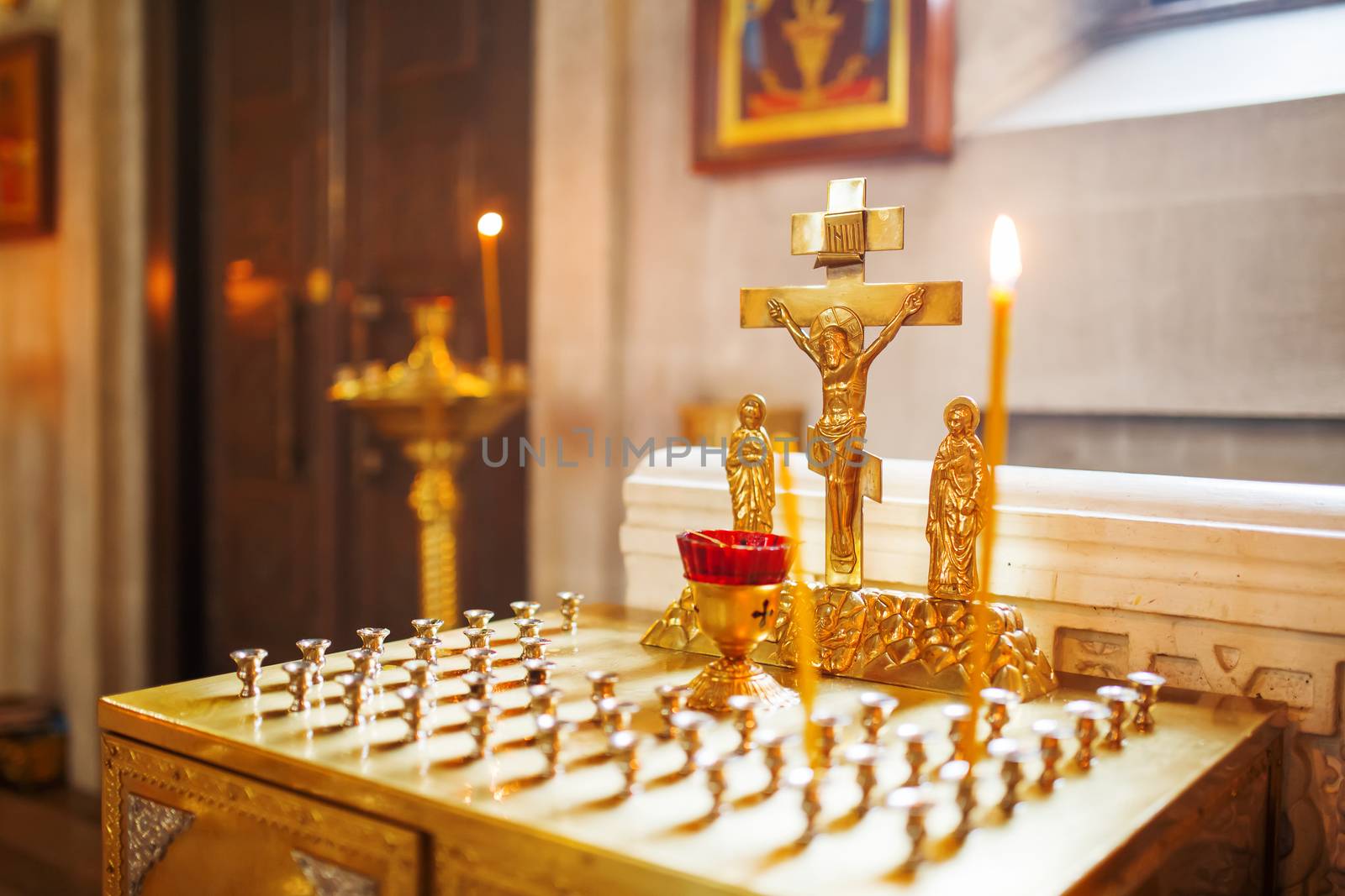Golden candleholder in Orthodox church. Symbolic Orthodox gold cross with the crucifixion of Jesus.