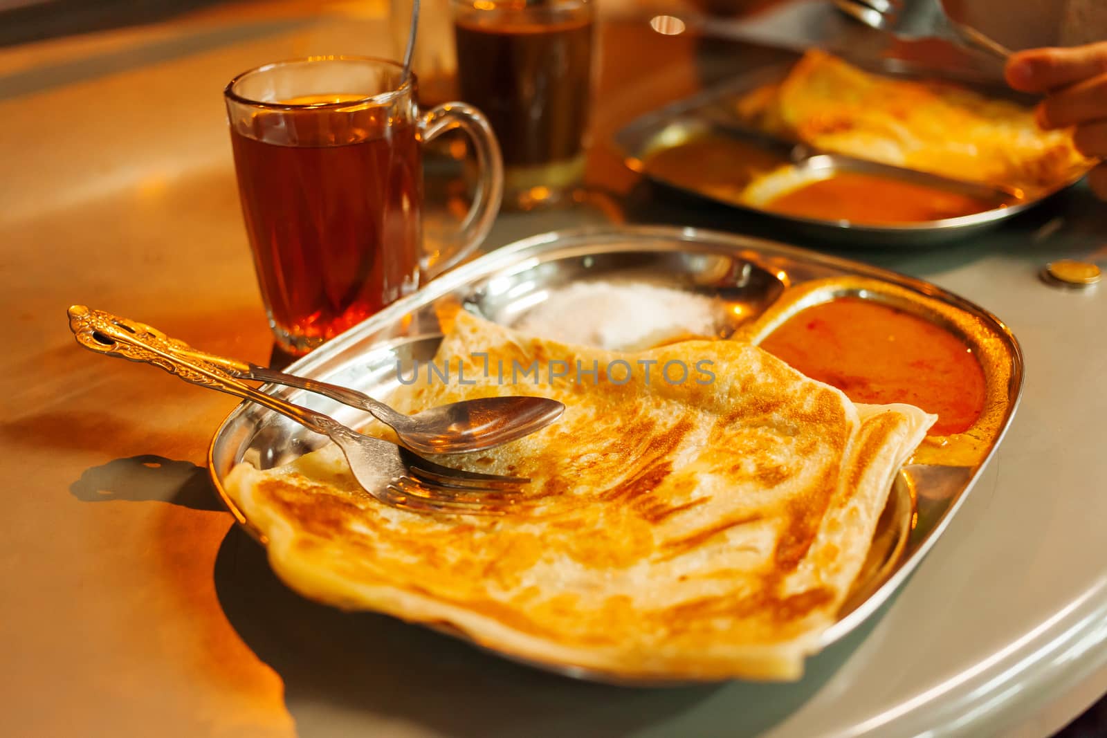 Chapati roti, Indian whole wheat flat bread, with spicy sauce and tea.