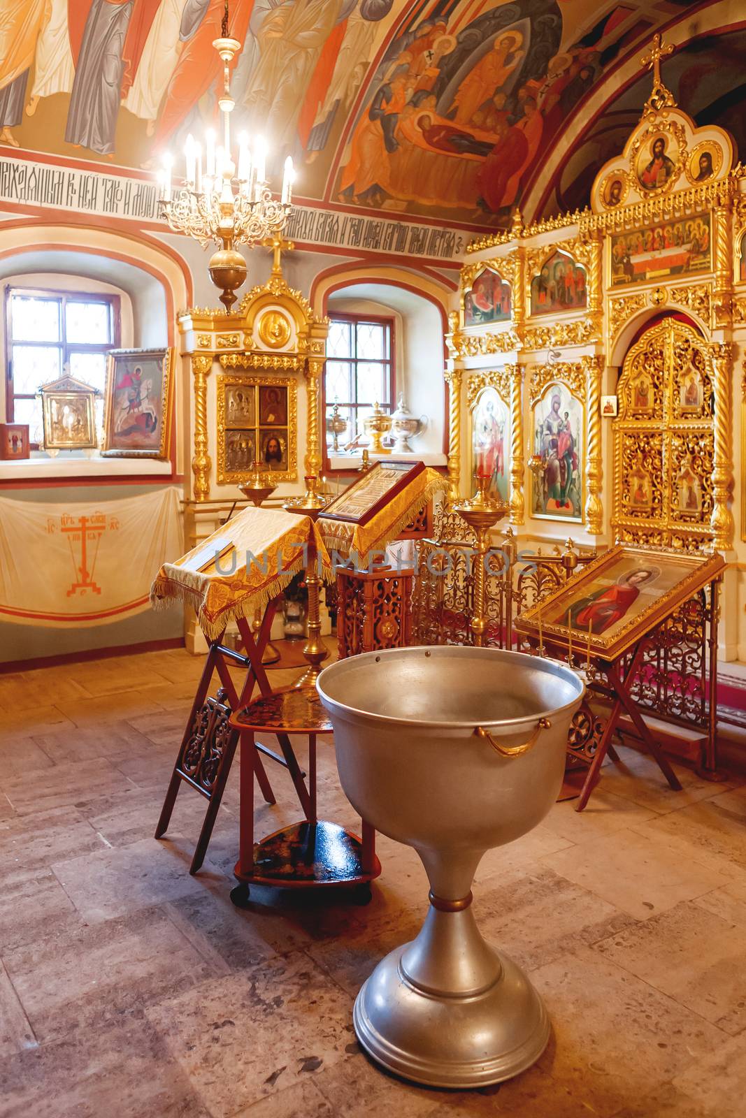 Golden religious utensils - Bible, cross, prayer book, missal, baptismal font. Interoior of Orthodox Christian Church. Russia.