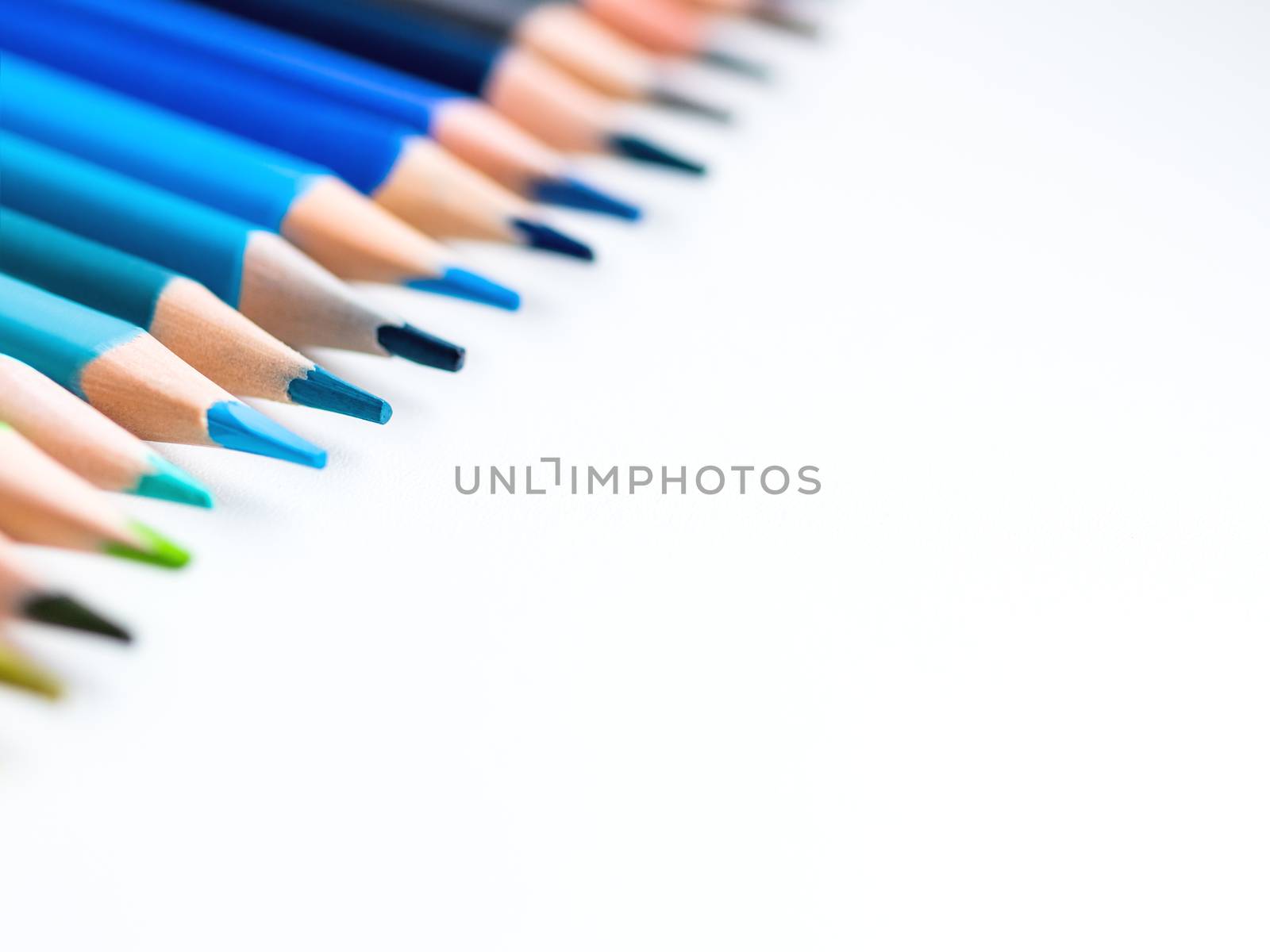 Row of colorful watercolor pencils on white background. School supplies. Kid's stationery with copy space. Back to school backdrop.