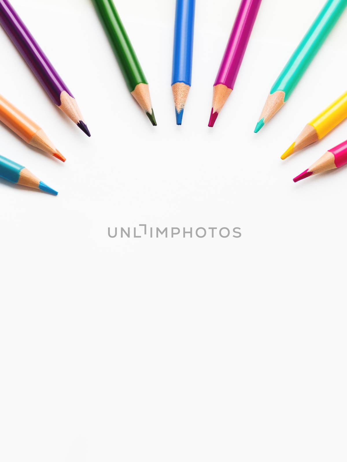 Colorful watercolor pencils on white background. School supplies with round copy space. Kid's stationery. Back to school circle backdrop.