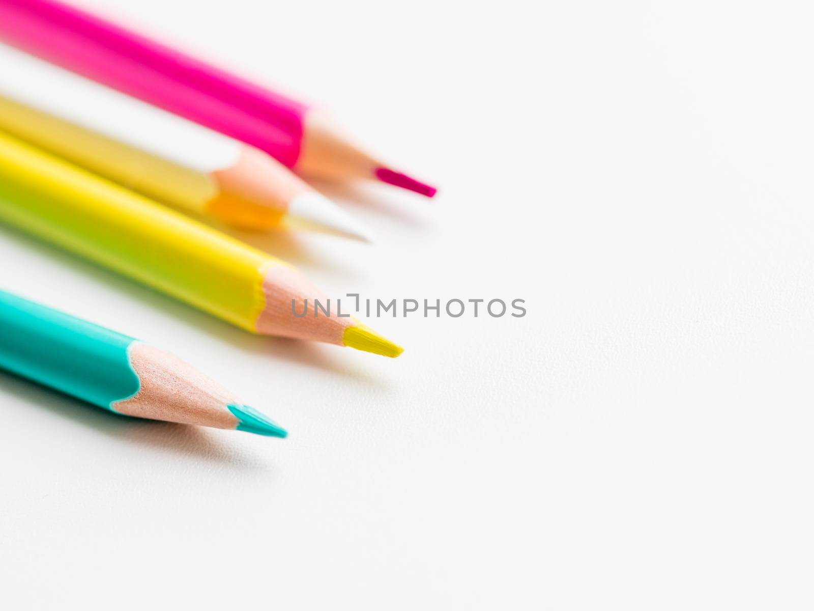 Colorful watercolor pencils on white background. School supplies with copy space. Kid's stationery. Back to school backdrop.