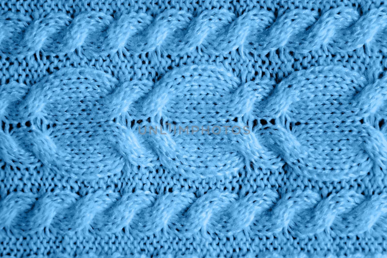 Abstract knitted background. Blue woolen sweater texture. Close up picture of knitted pattern.