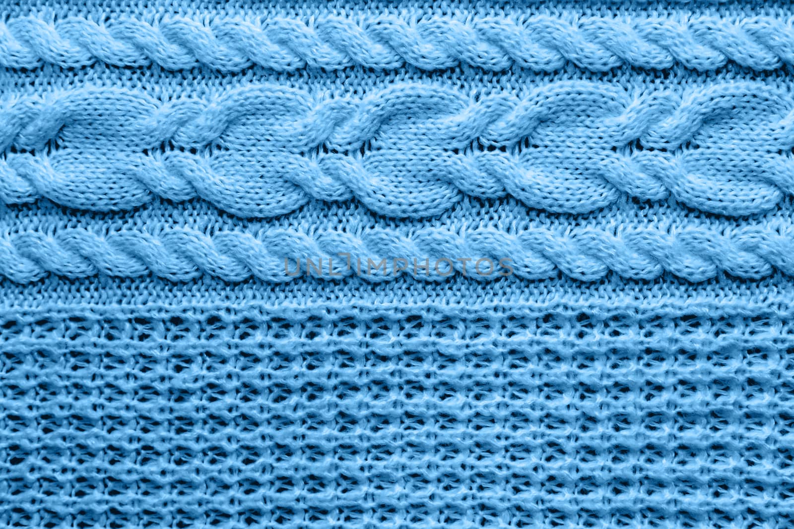 Abstract knitted background. Blue woolen sweater texture. Close up picture of knitted pattern.