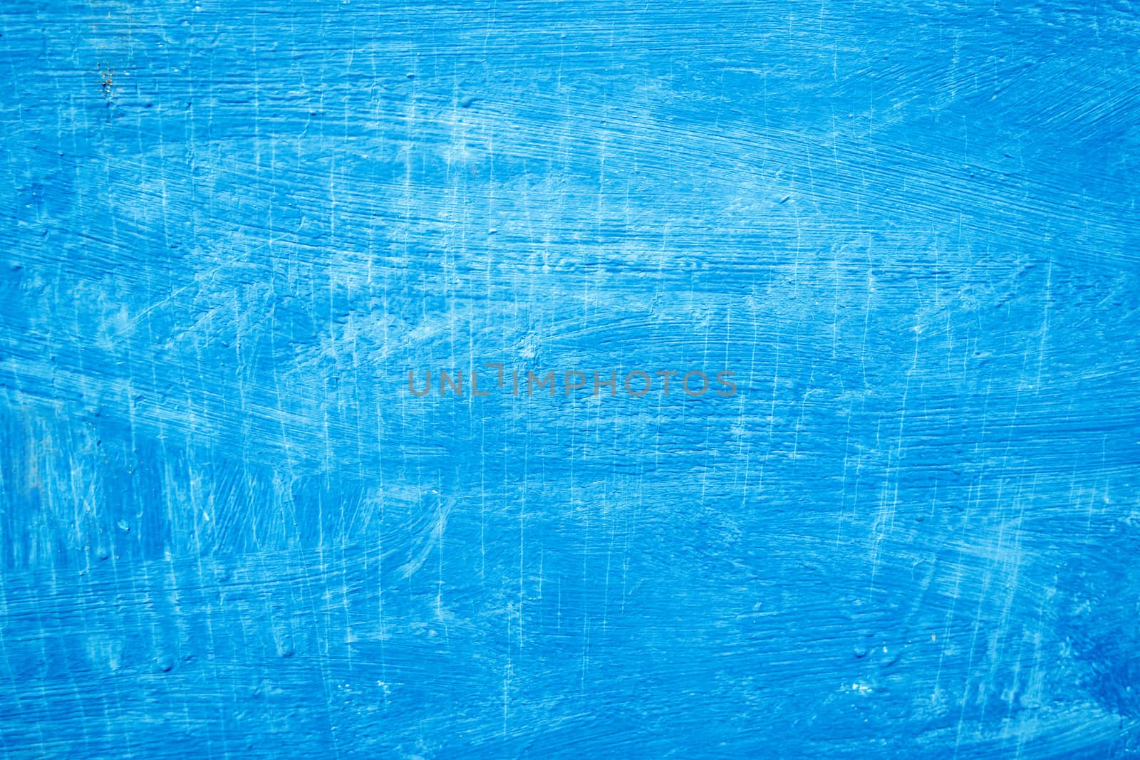 Abstract background with textured strokes of blue paint on the wooden surface.