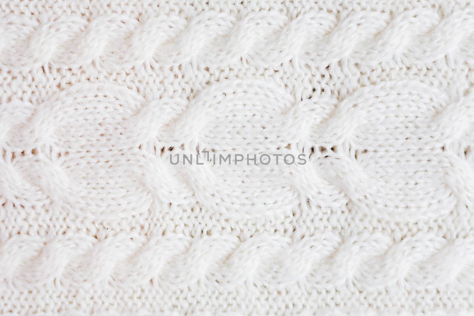 Abstract knitted background. Wool white sweater texture. Close up picture of knitted pattern.