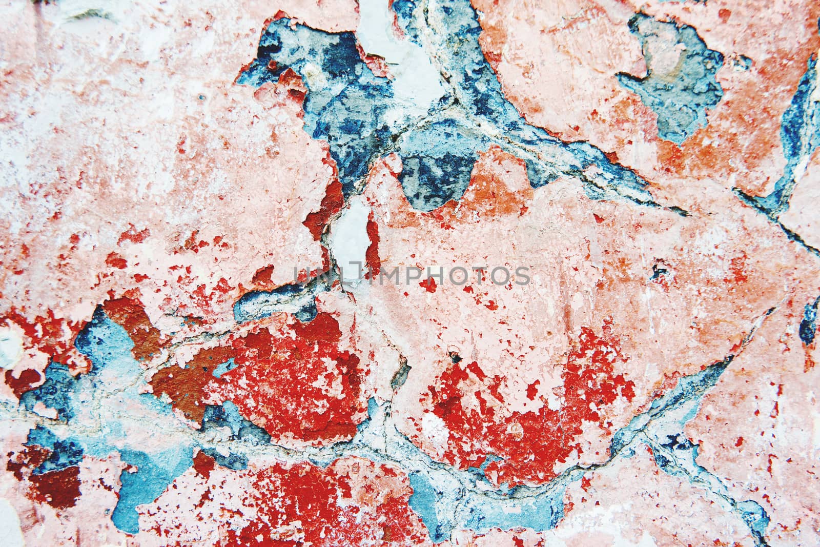 Stone background of old wall with peeling paint. Shabby texture of red and blue colored wall.