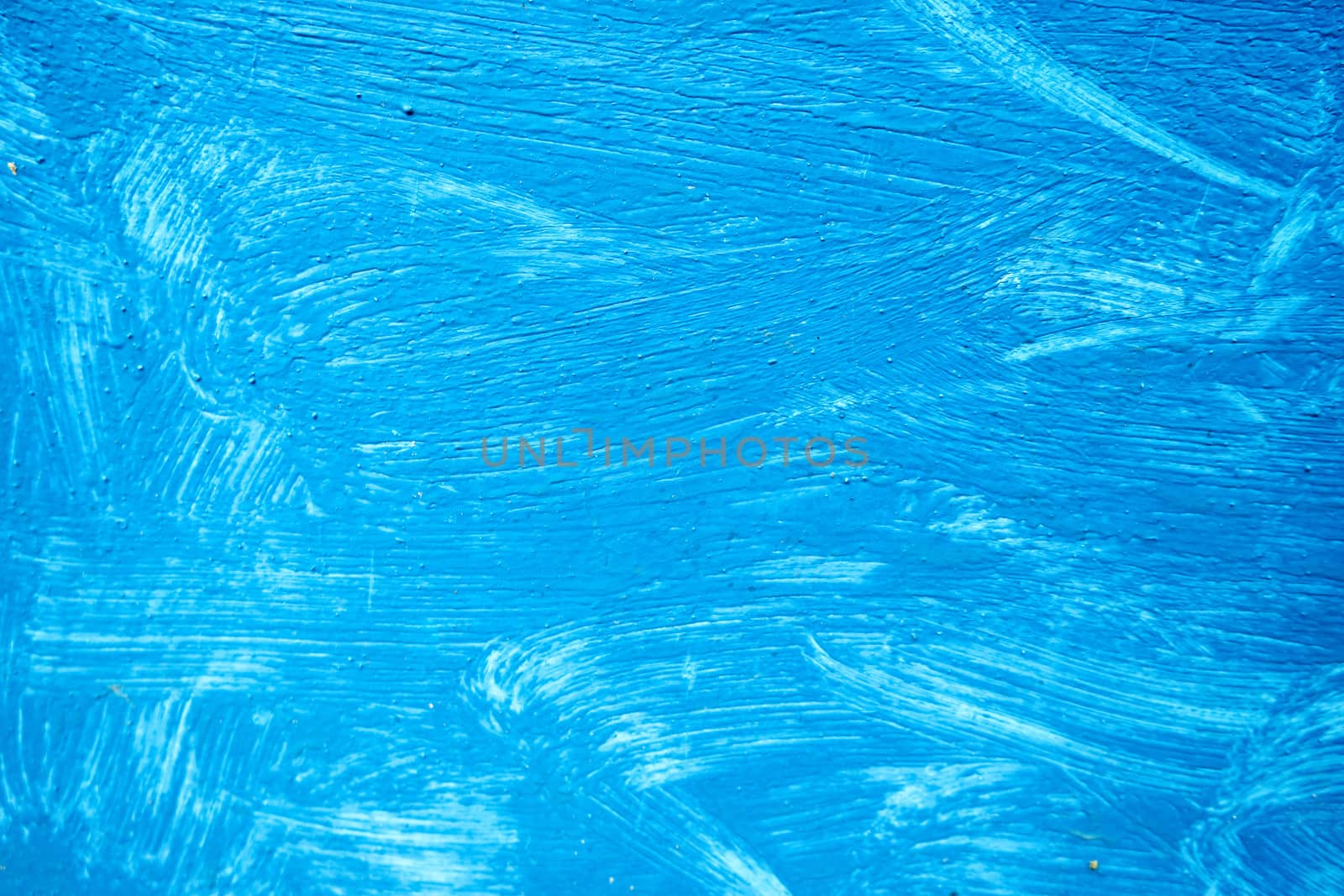 Abstract background with textured strokes of blue paint on the wooden surface.