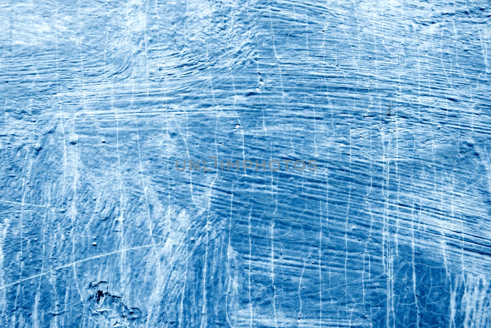 Abstract background with textured strokes of blue paint on the wooden surface.