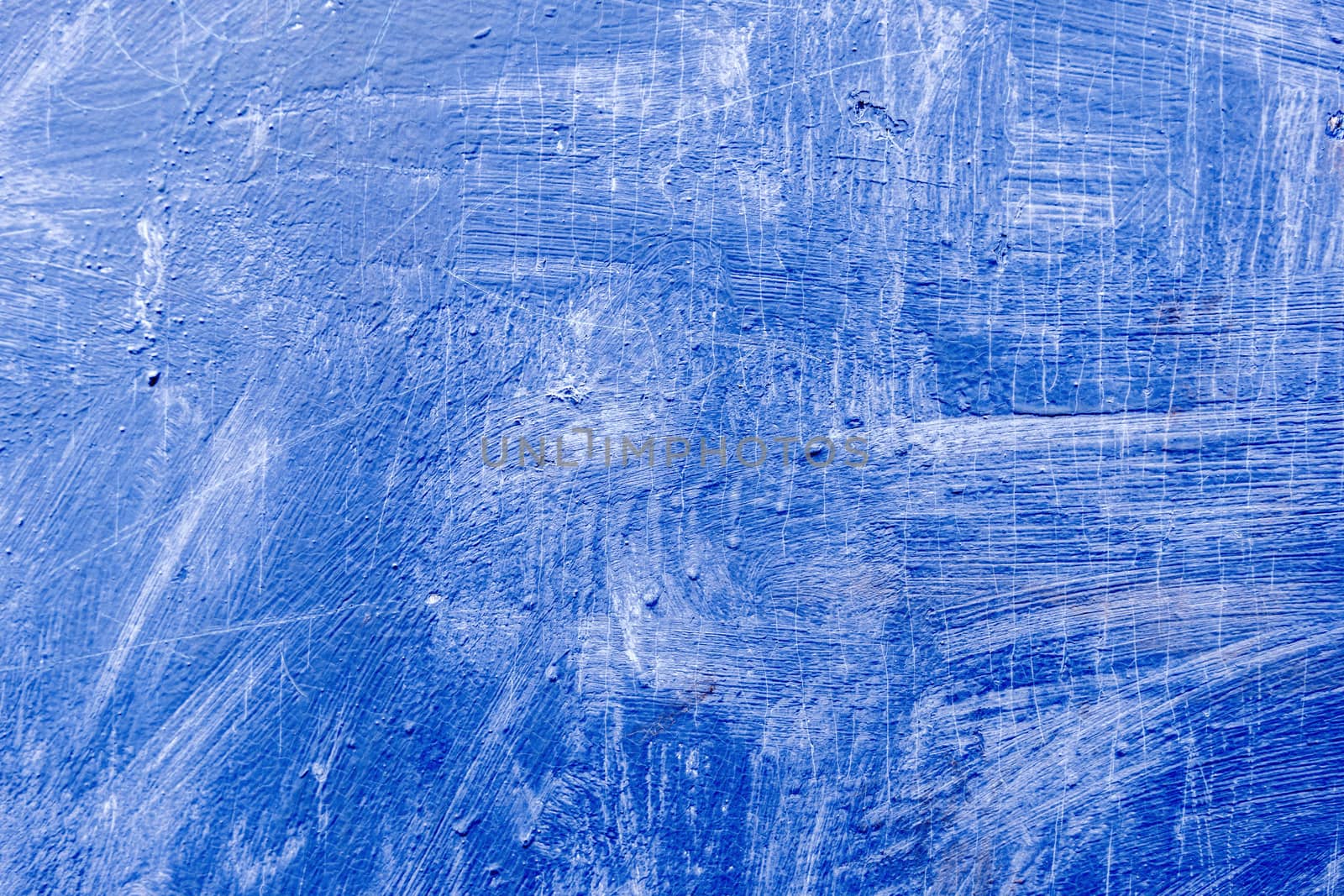 Abstract background with textured strokes of blue paint on the wooden surface.