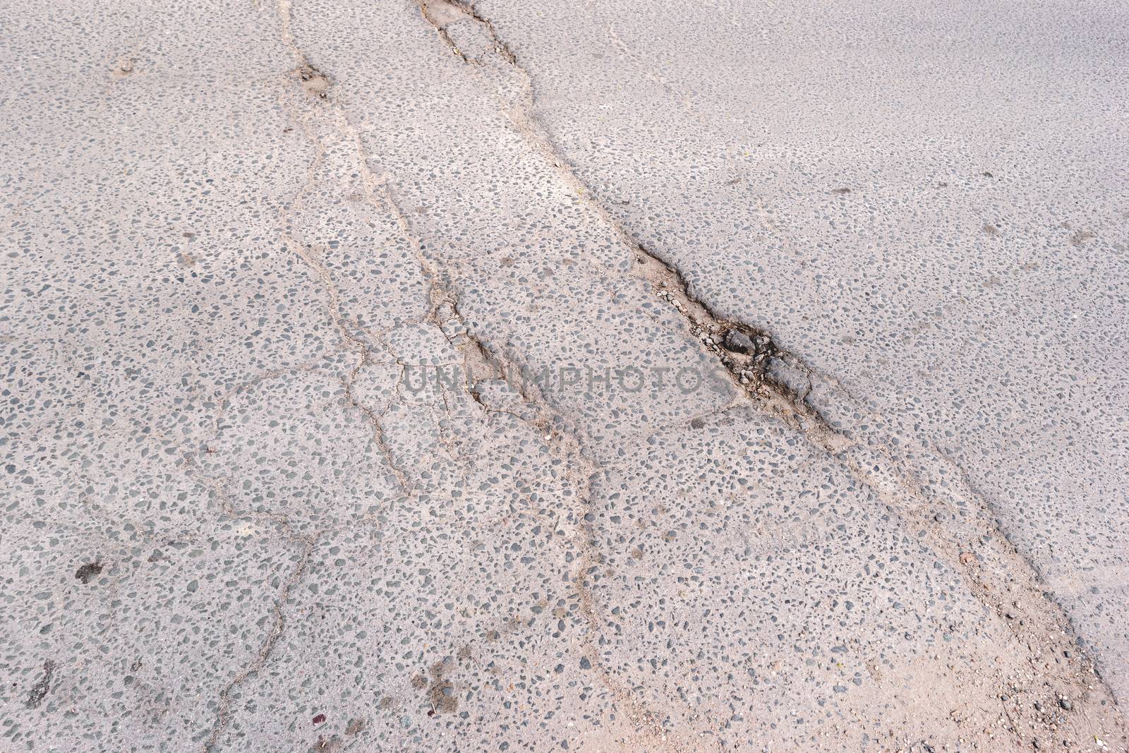 Crack in asphalt. Damaged pavement. Poor condition of the road surface.