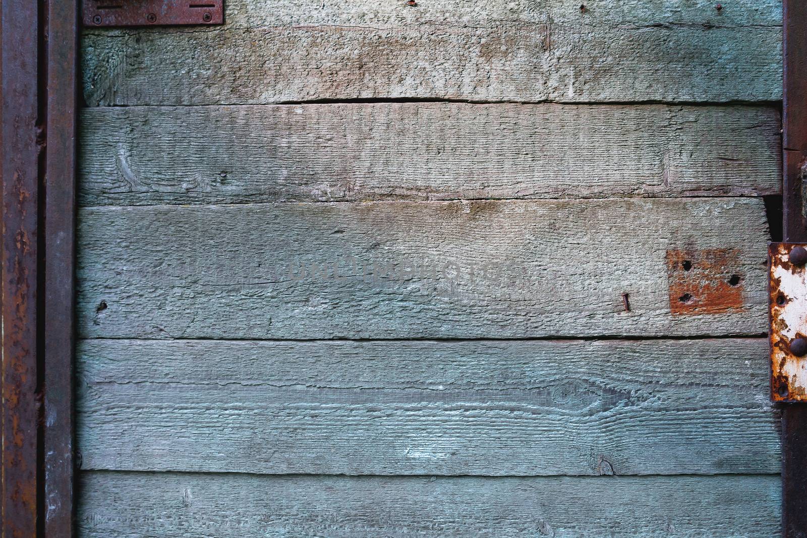 Wooden background of old door with rusty accessories.