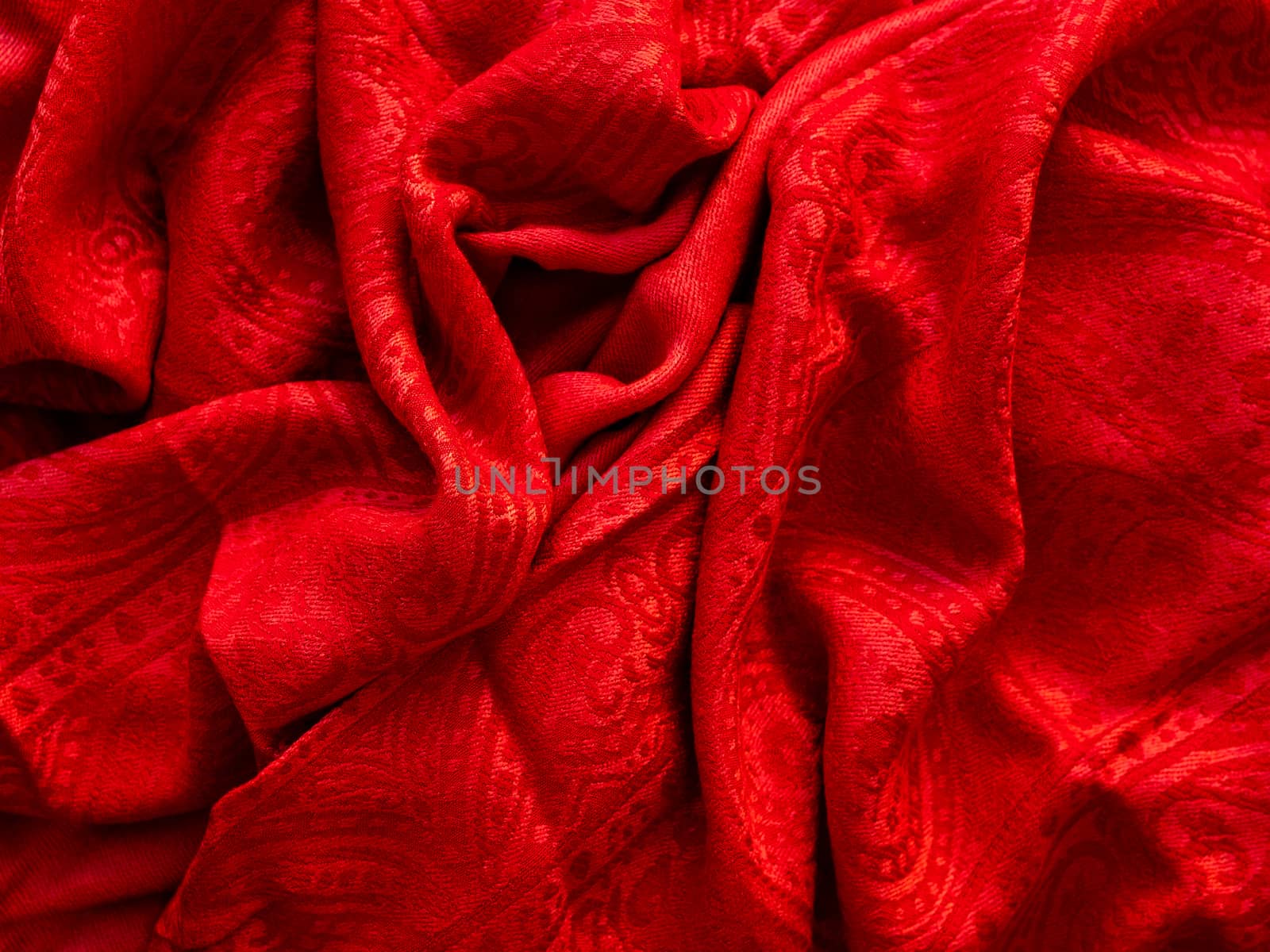 Bright red scarf. Folded warm accessory. Textile background.