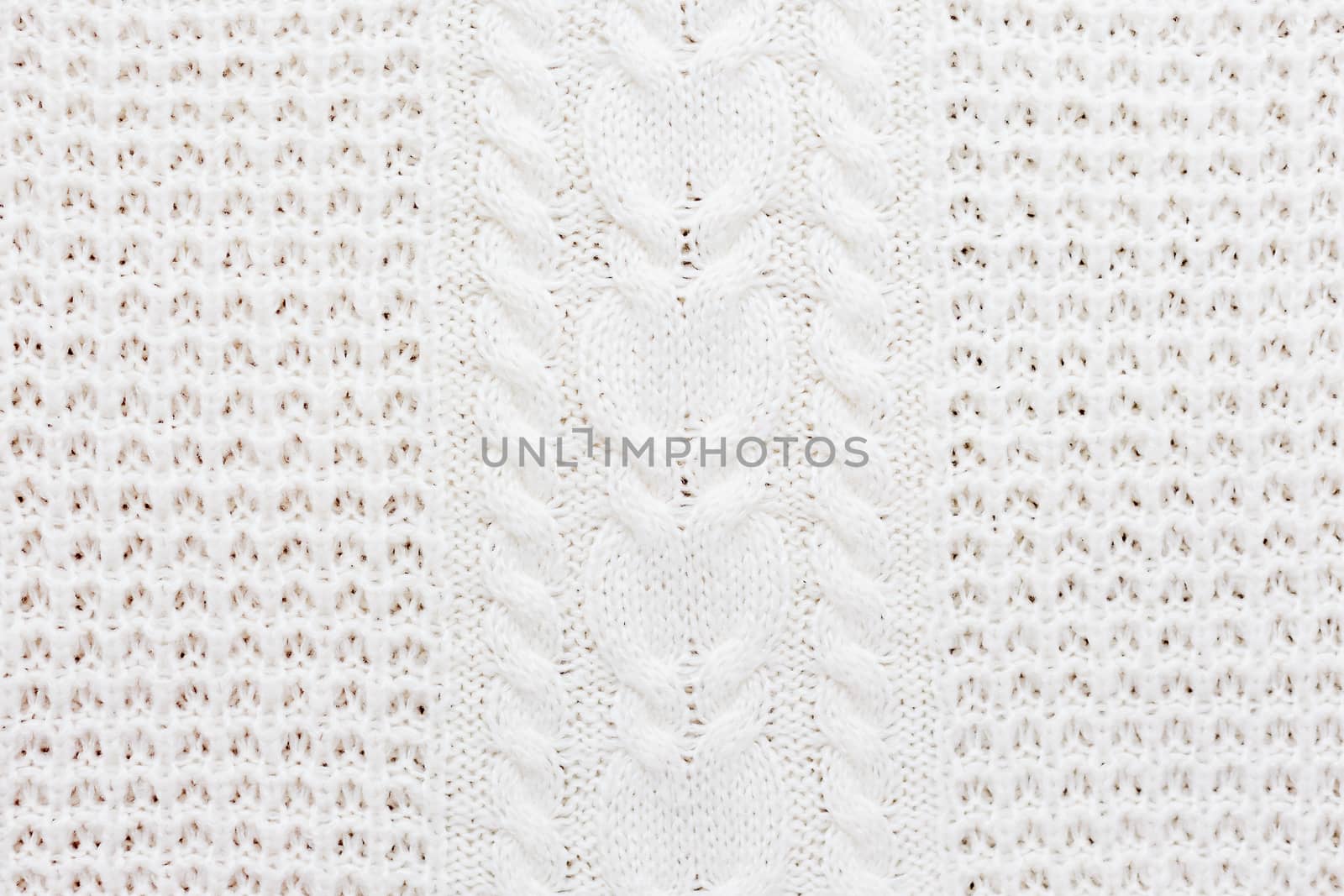 Abstract knitted background. Wool white sweater texture. Close up picture of knitted pattern.