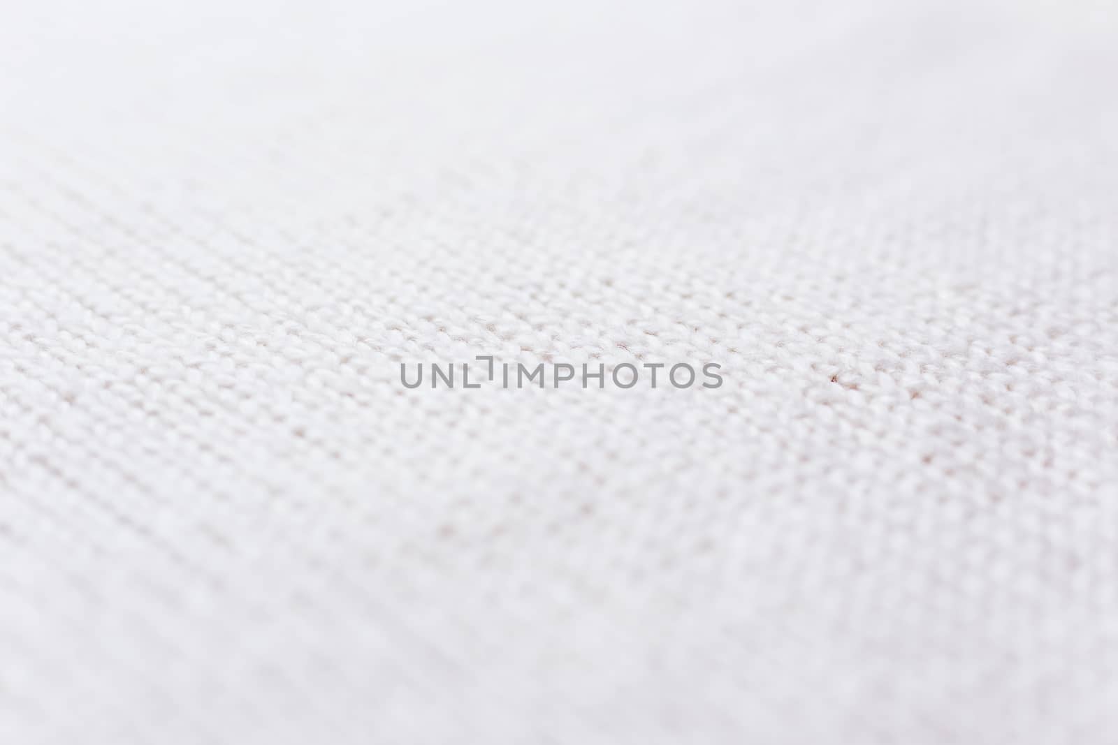 Abstract knitted background. Wool white sweater texture. Diagonal close up picture of knitted pattern.