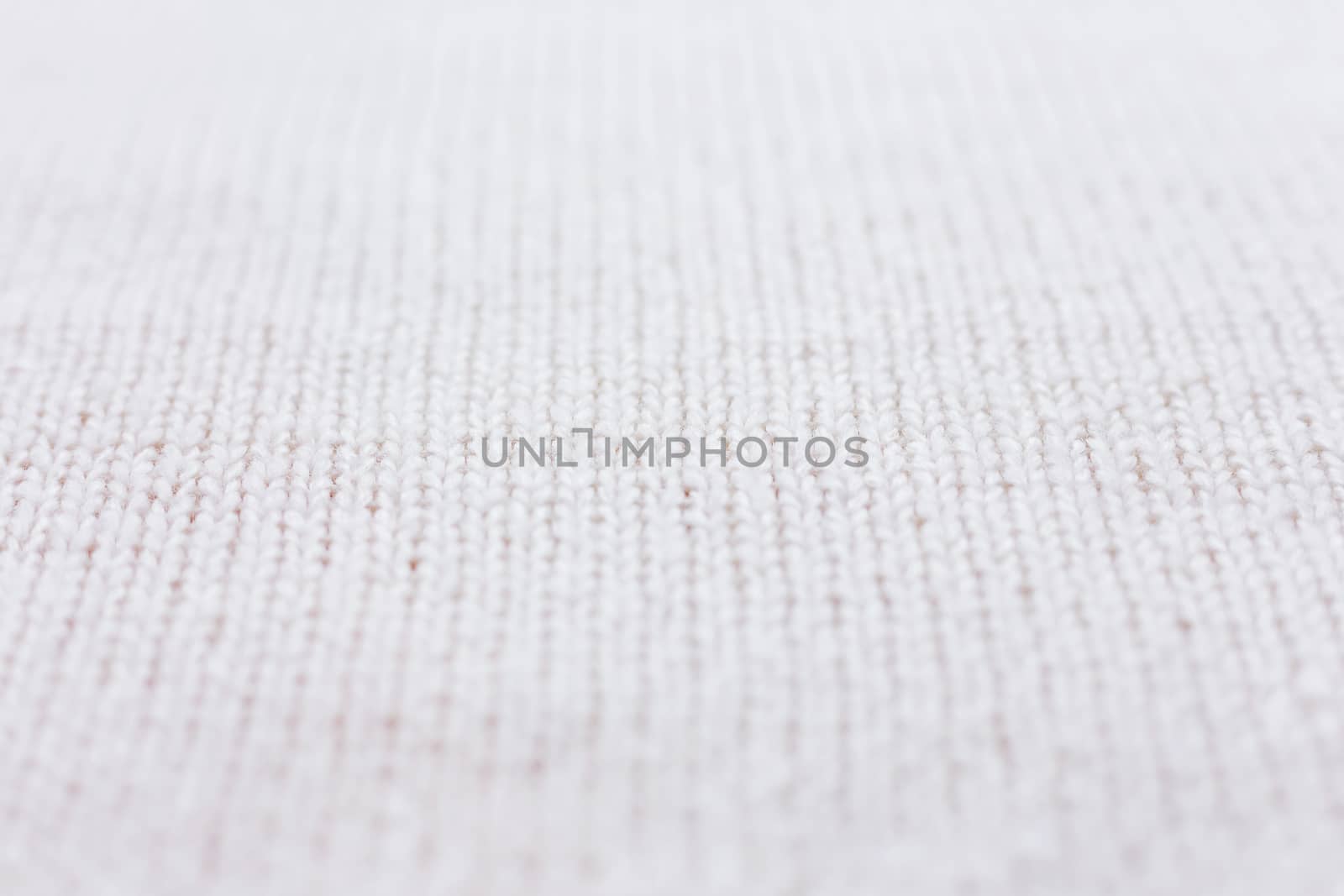Abstract knitted background. Wool white sweater texture. Close up picture of knitted pattern.